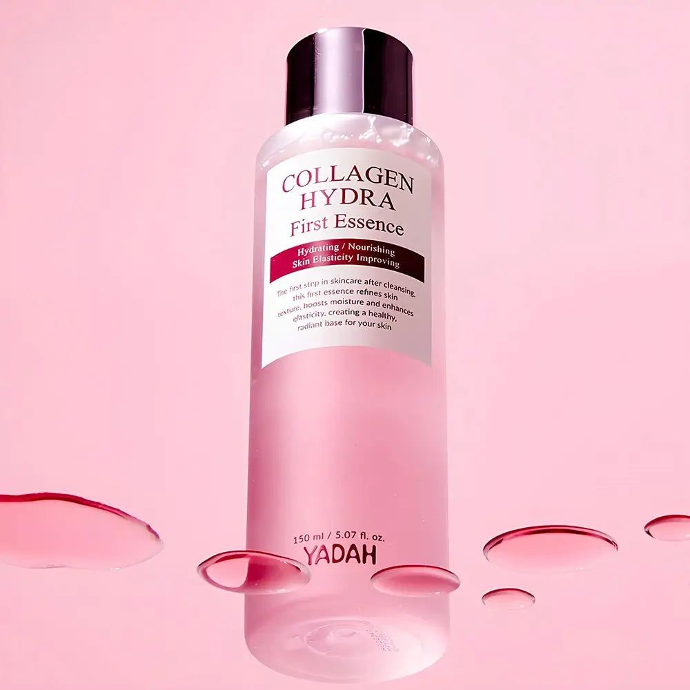 Transparente Flasche mit rosa Flüssigkeit. Aufschrift: Collagen Hydra First Essence. Rosa Flüssigkeit im Hintergrund.