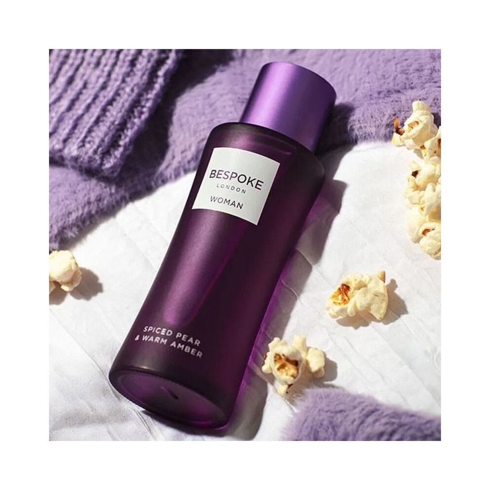 Violette Flasche mit lila Verschluss. Aufkleber mit Text. Umgeben von Popcorn und lila Textilien.