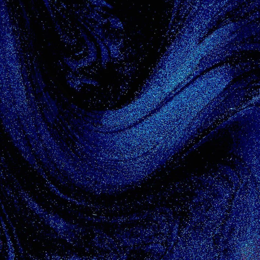 Abstrakte Nahaufnahme von blauem Glitzer in dunklem Hintergrund.