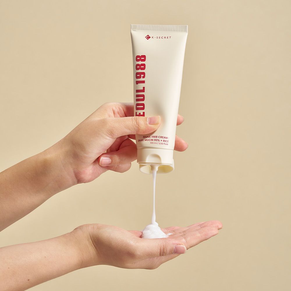 Eine Hand gibt SEOUL 1988 Cream aus einer Tube in die andere Hand.