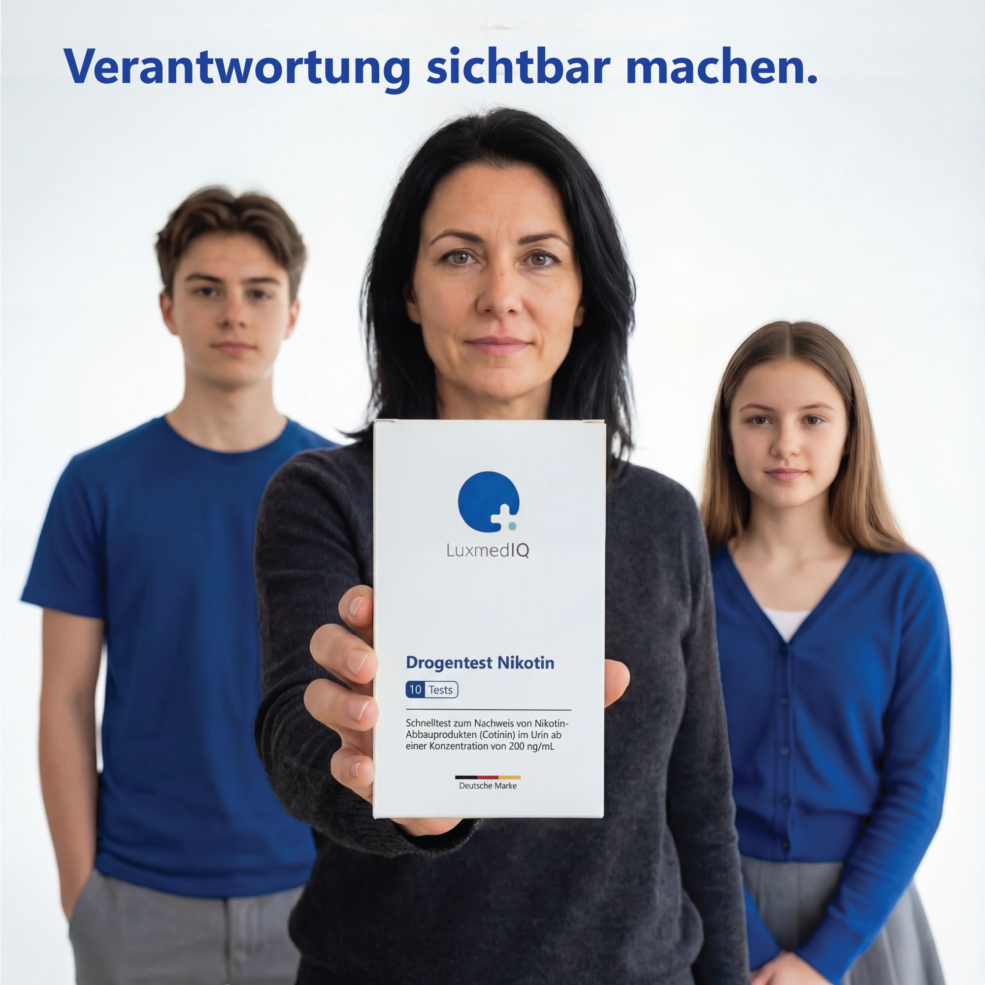 Eine Frau hält eine Packung LuxmedIQ Drogentest Nikotin. Zwei Jugendliche stehen hinter ihr.