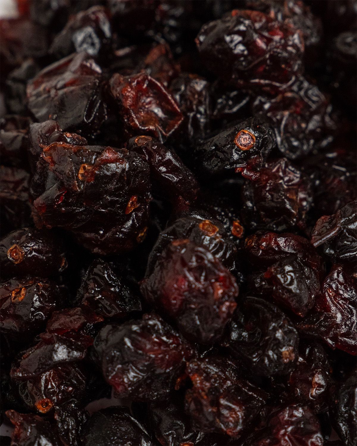 Nahaufnahme getrockneter Cranberries. Dunkelrote Früchte, unscharfer Hintergrund.