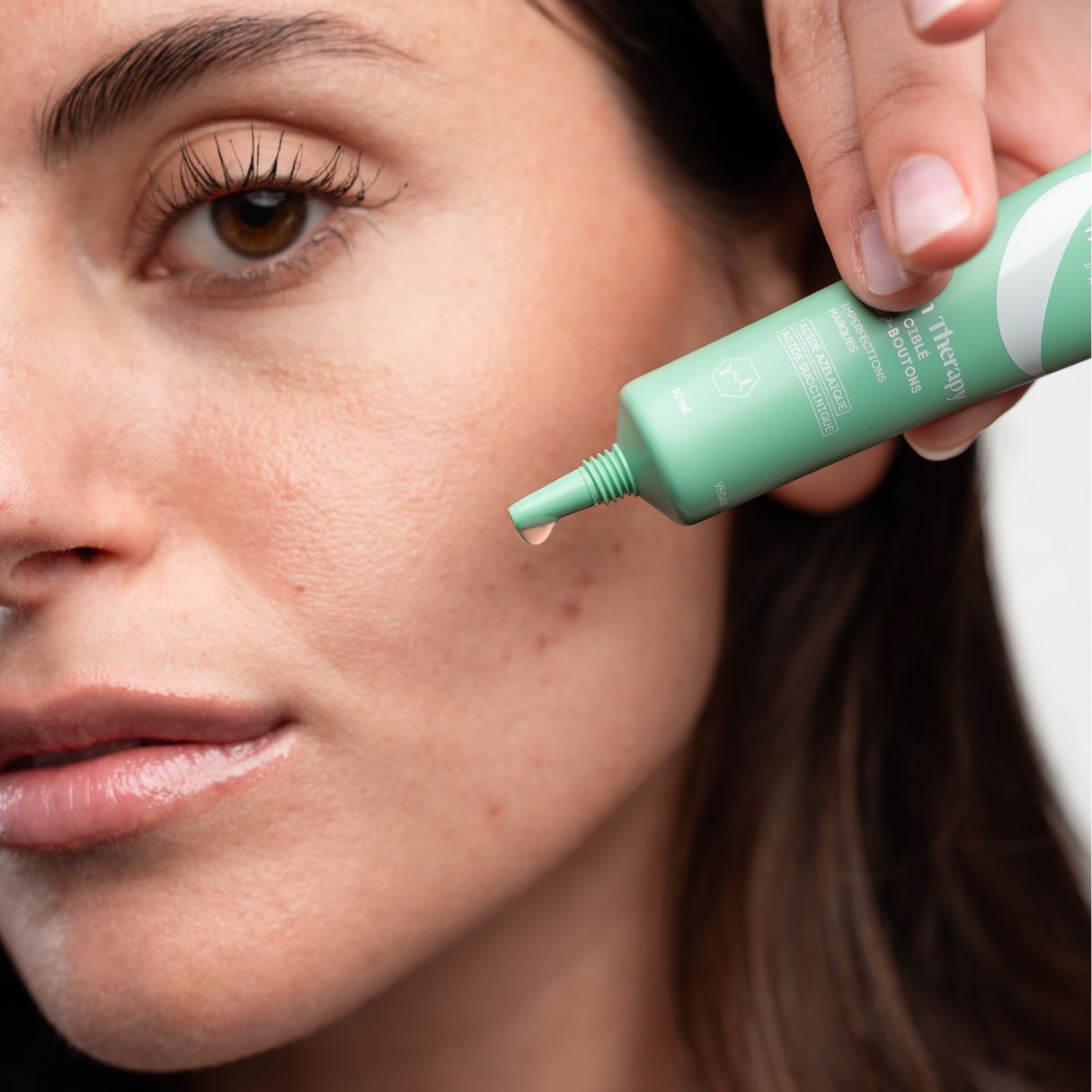 Grüne Tube, Tropfen. Produkt wird auf Haut aufgetragen. Text: Skin Therapy, Cure & Routine.