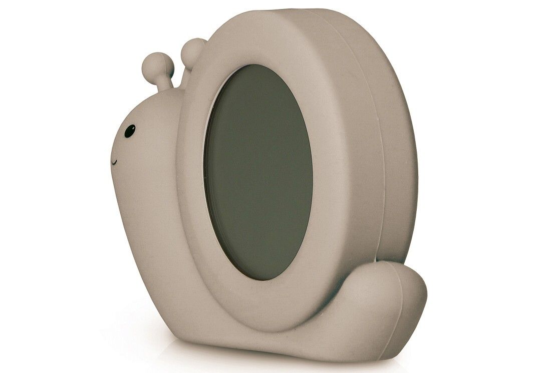 Beigefarbener Schlaftrainer in Schneckenform. Rückseite mit leerem Display. Gehäuse in Schneckenform.