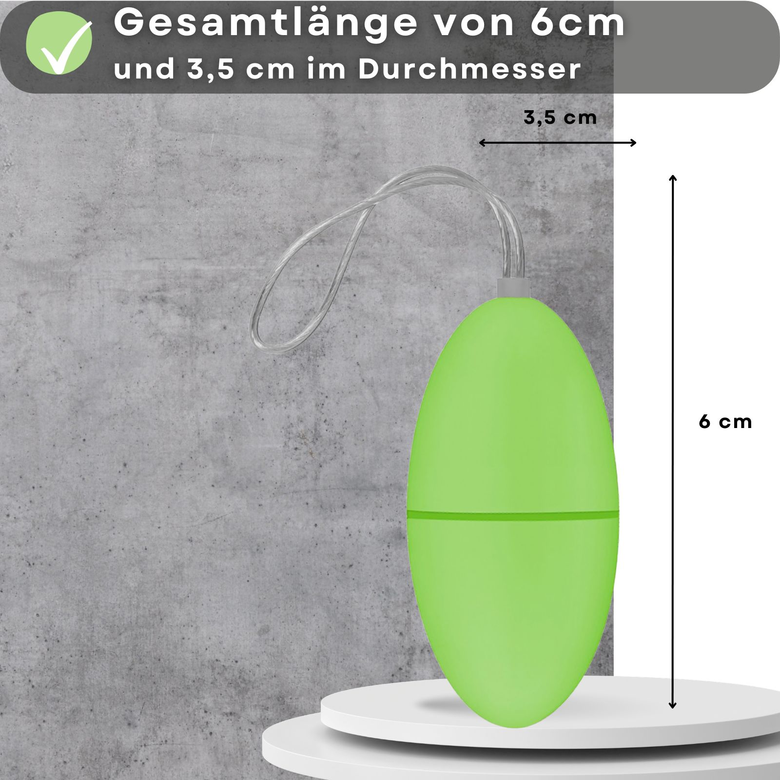 Grünes, ovales Produkt mit Schnur. Maße: 6 cm lang, 3,5 cm Durchmesser. Auf weißem Podest.