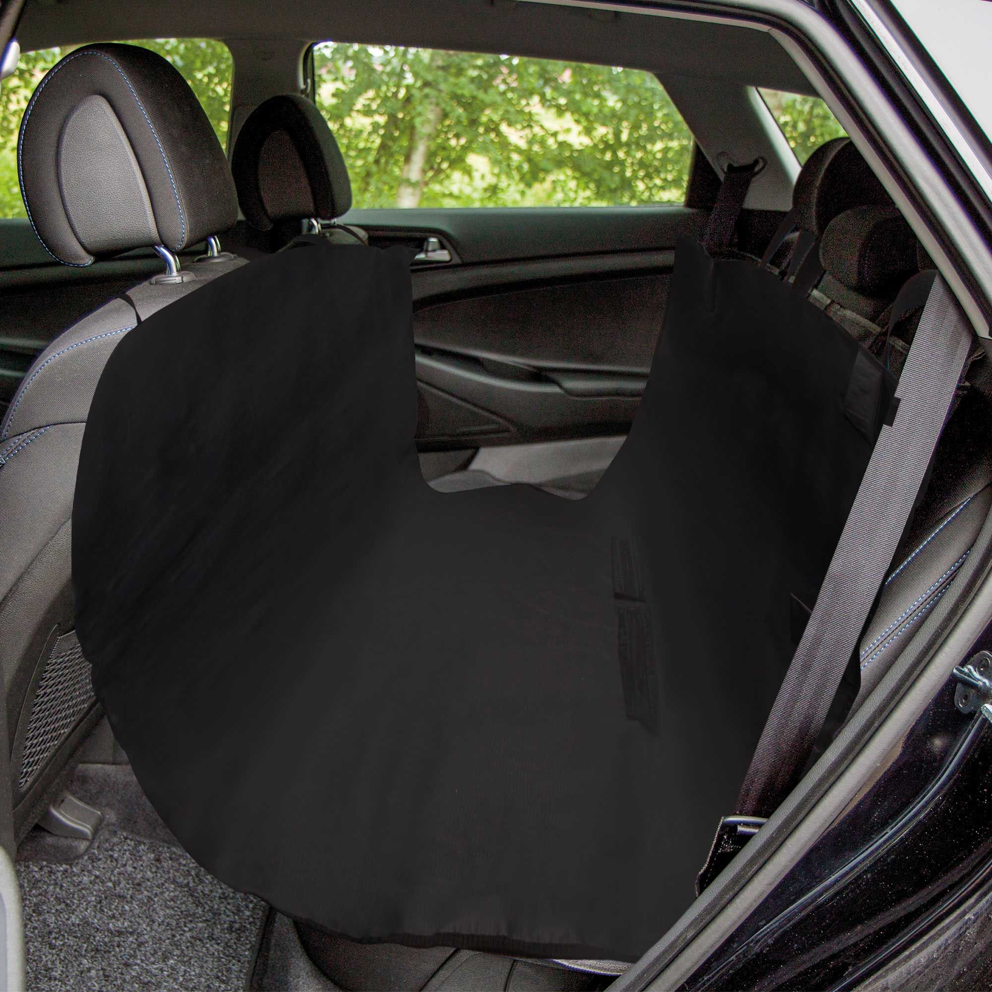 Schwarze Auto-Schondecke im Auto, auf dem Rücksitz platziert. Mit Sicherheitsgurt. Blick von der Seite.