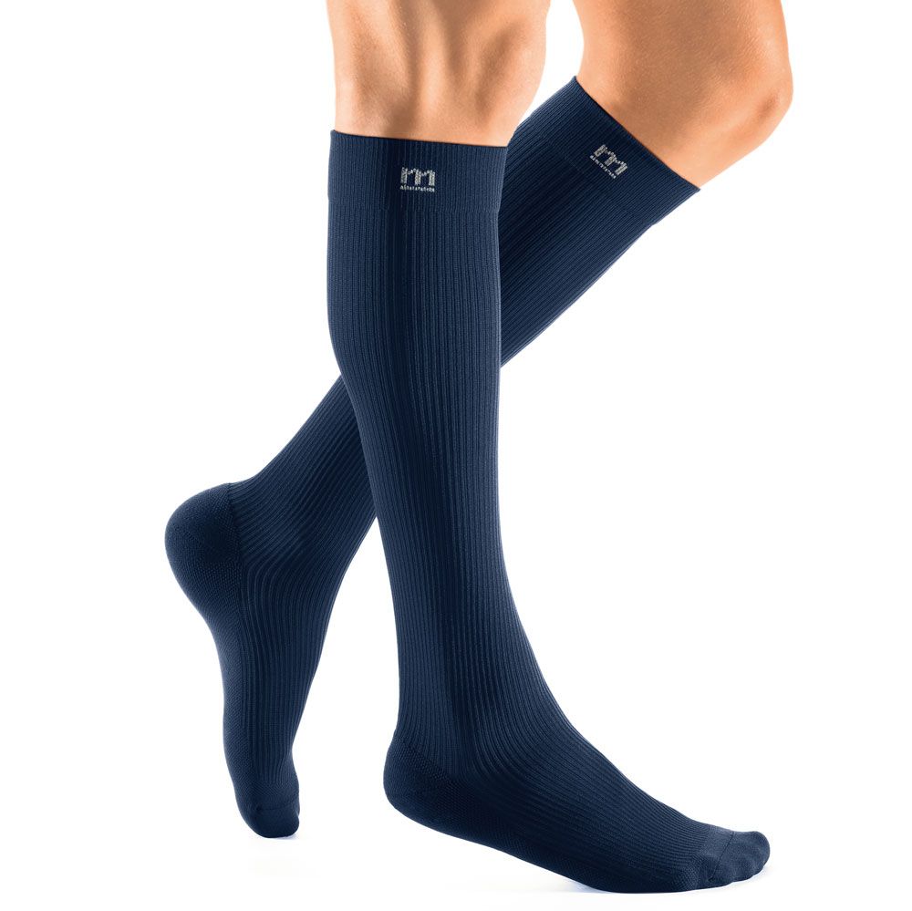 Marineblaue Kompressionsstrümpfe mit Rippmuster und Logo. Trikotabschlussrand. Auf einem Bein getragen.