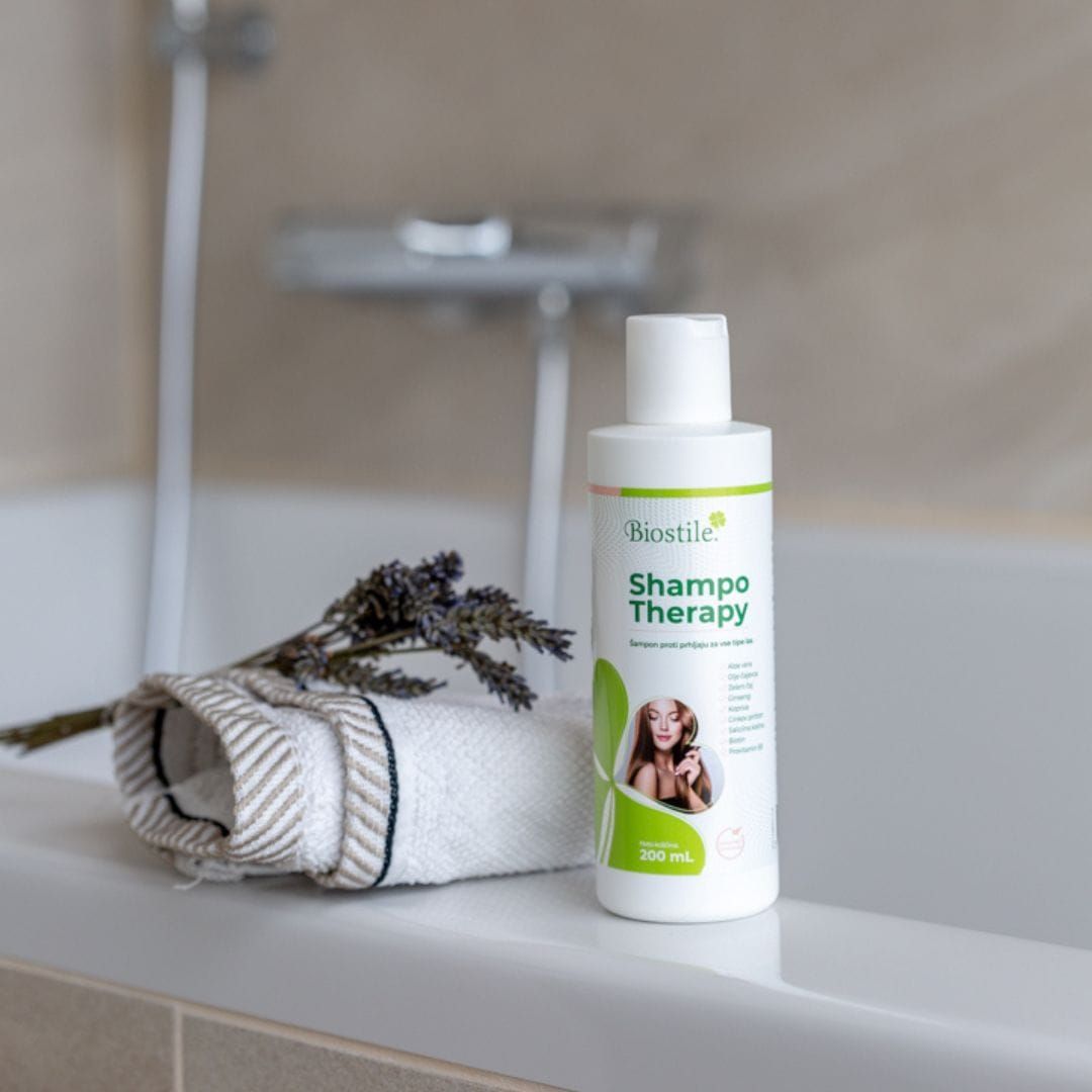 Biostile Shampoo-Therapie Flasche. Weiß, mit grünem Etikett. Auf Badewannenrand, neben Handtuch und Lavendel.