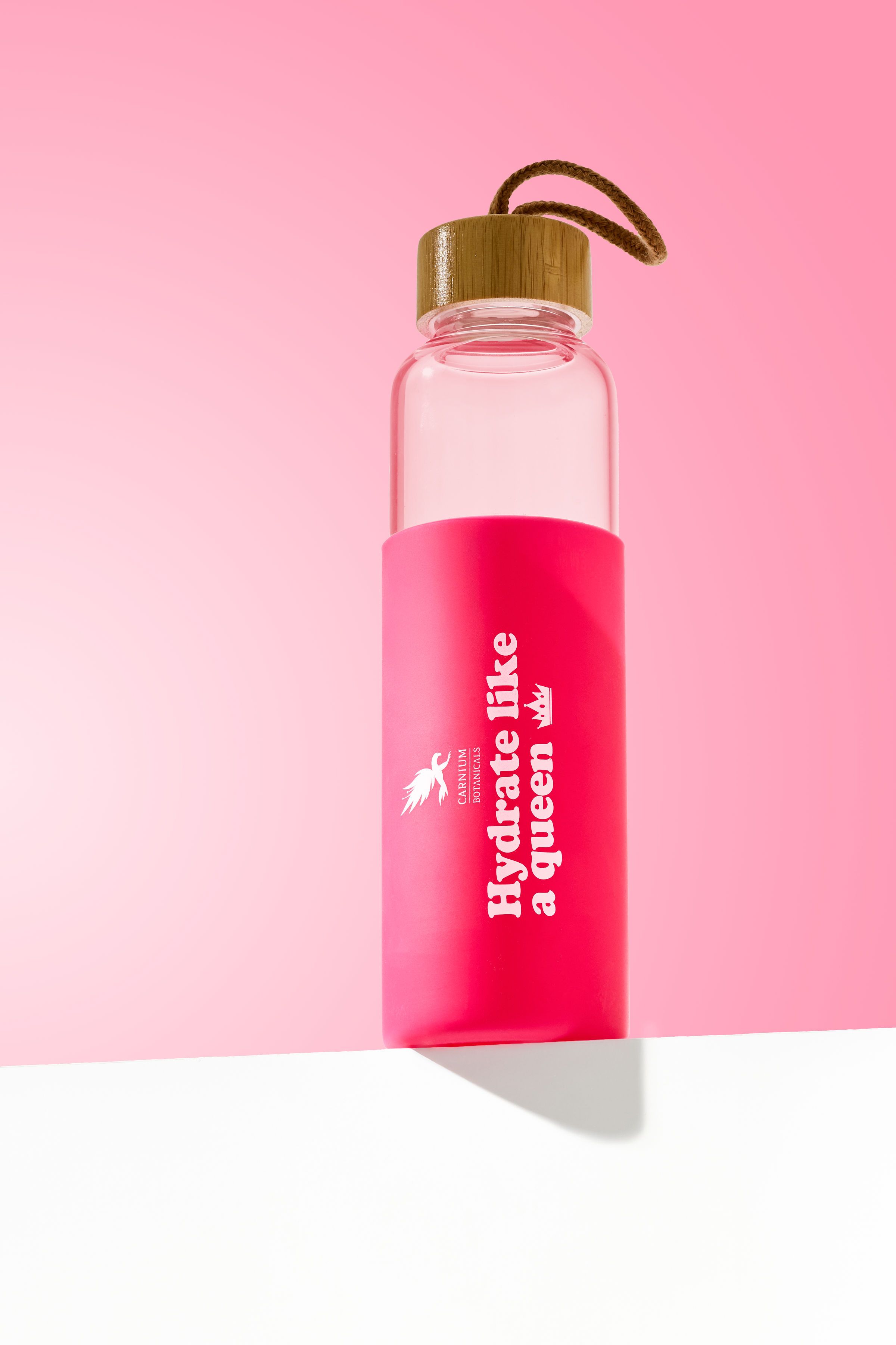 Trinkflasche mit rosa Hülle und Aufschrift. Bambusdeckel mit Schlaufe. Aufschrift: Hydrate like a queen.