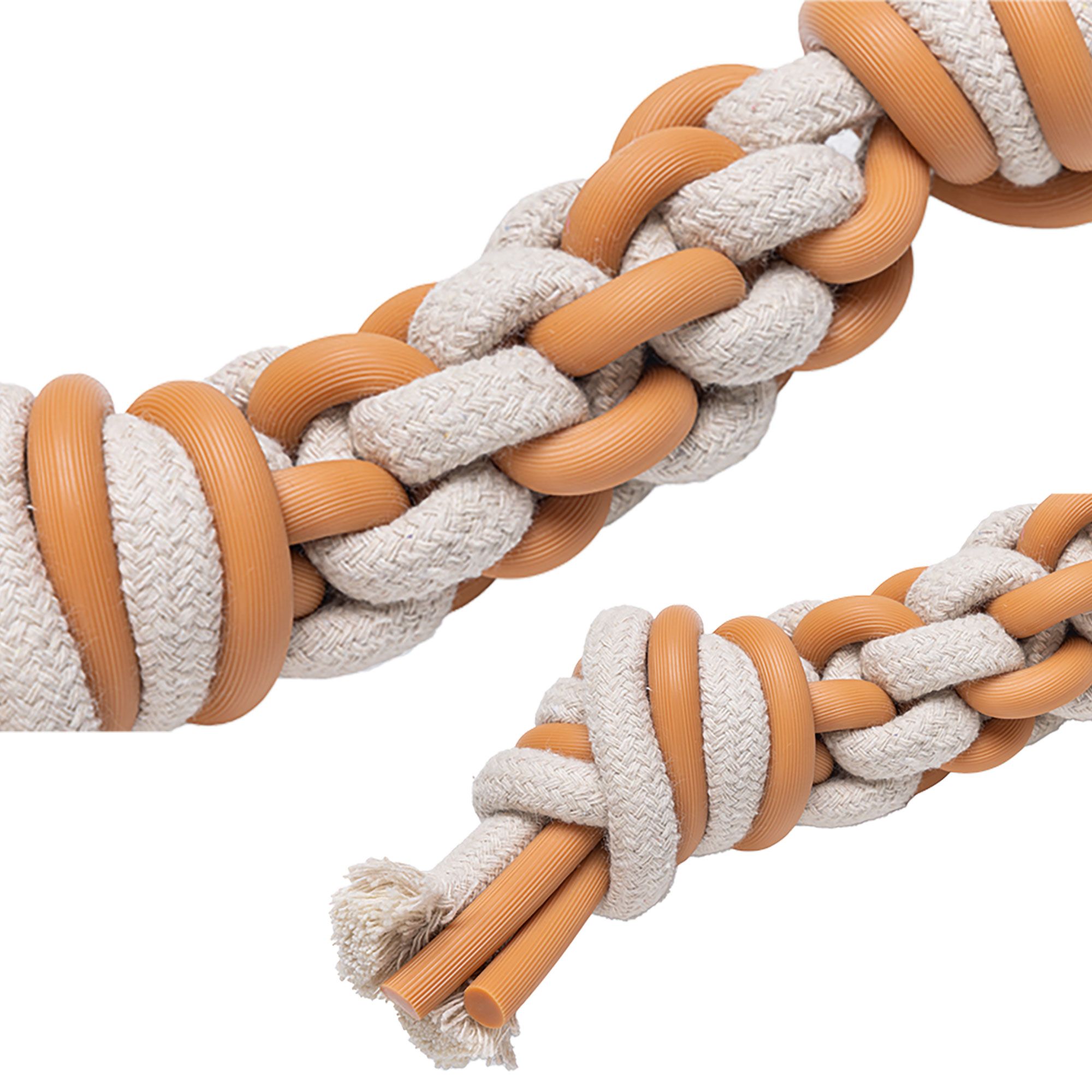 Nahaufnahme des Zahnpflegespielzeugs. Geflochtenes Seil mit orangefarbenen Ringen und Enden. Beige und orangefarbene Farben.