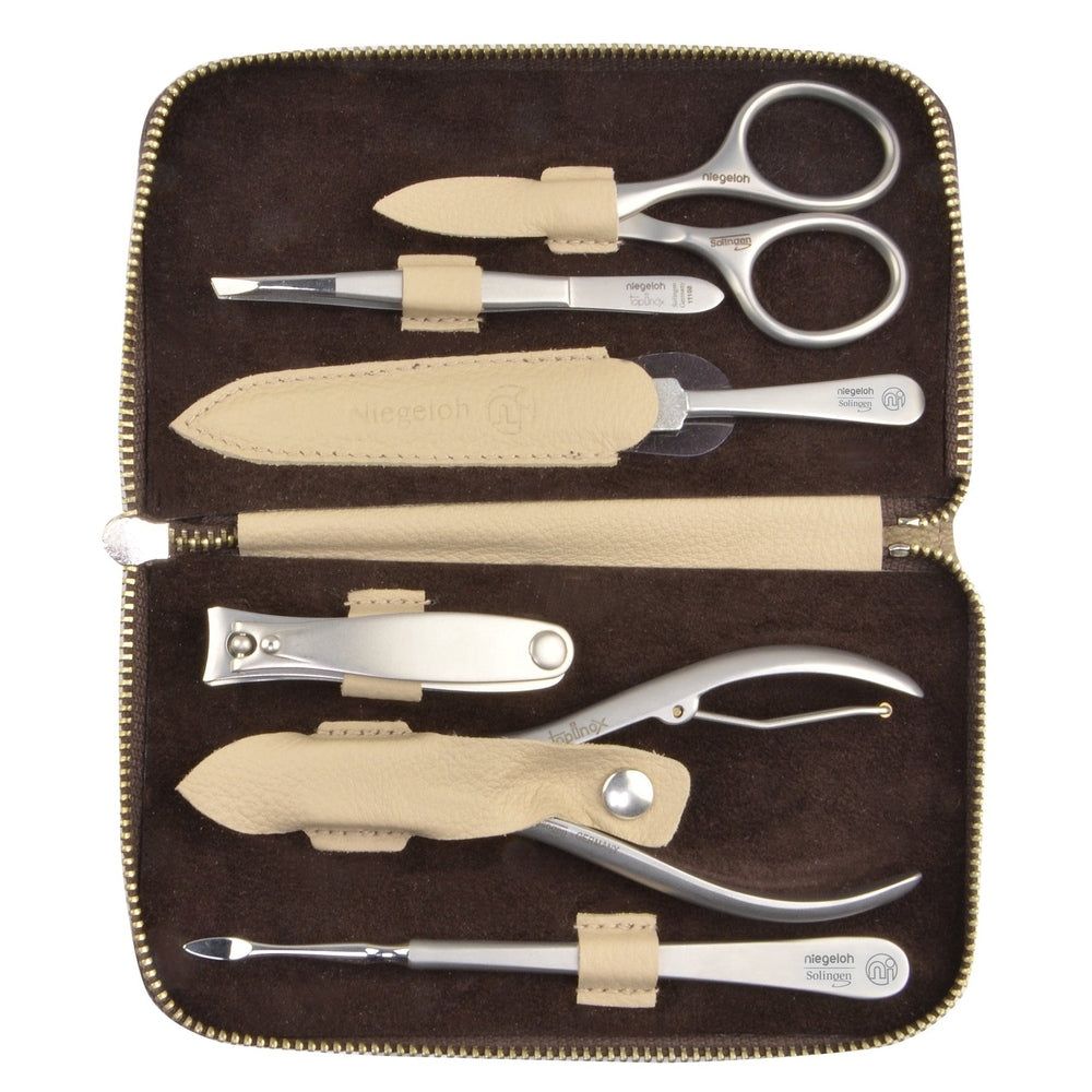 Geöffnete braune Kosmetiktasche mit Maniküre-Werkzeugen. Enthalten sind Schere, Pinzette, Nagelfeile, Nagelknipser und mehr.