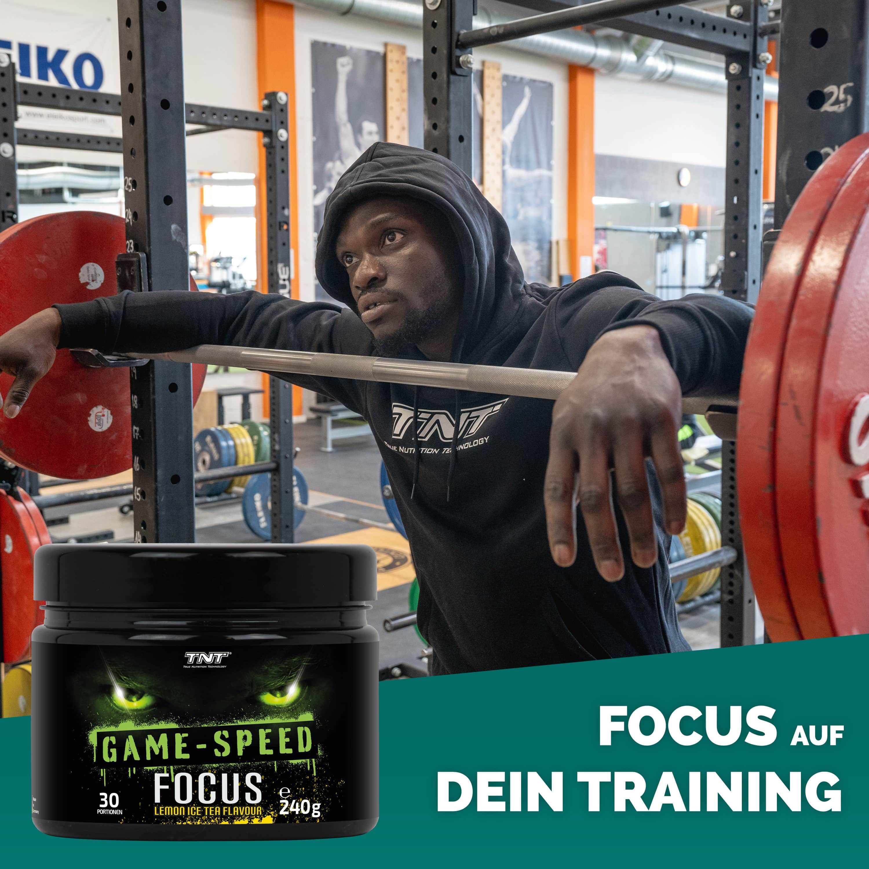 Mann lehnt an Hantelstange. Dose mit grünem Etikett. Text: GAME-SPEED FOCUS, 30 Portionen, 240g, Lemon Ice Tea Flavour. TNT Logo.