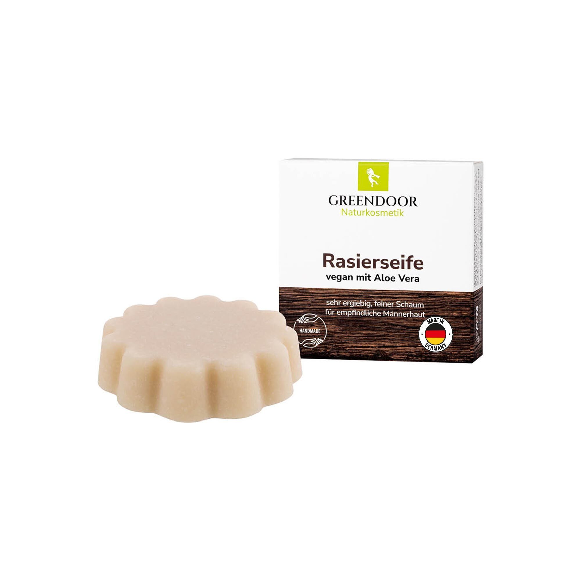 GREENDOOR Rasierseife vegan mit Aloe Vera, runde Form, neben der Verpackung.
