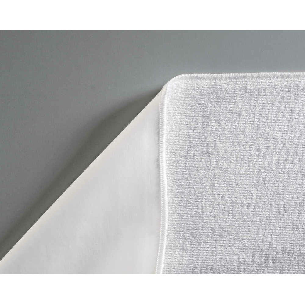 Nahaufnahme eines weißen Frottee-Matratzenschoners. PU-Beschichtung sichtbar.