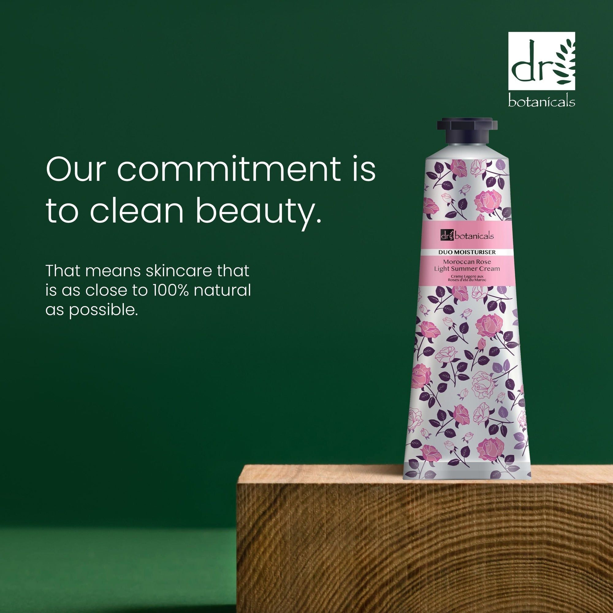 Tube mit floralem Muster auf Holzblock. Text: Our commitment is to clean beauty. Skincare that is as close to 100% natural as possible.