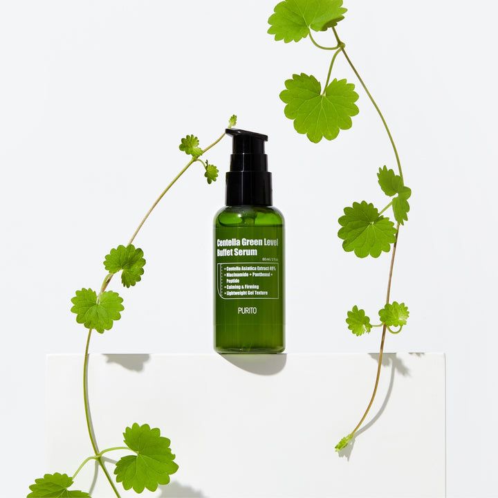 Grüne Serumflasche mit schwarzem Pumpverschluss, umgeben von grünen Blättern. Produktname und Marke PURITO sichtbar.