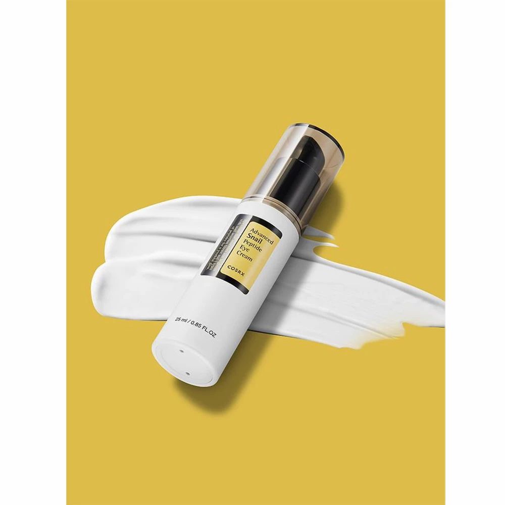 Produktflasche auf gelbem Hintergrund mit Creme-Ausstrich. Schwarzer Pumpkopf. Produktname und Marke sichtbar.