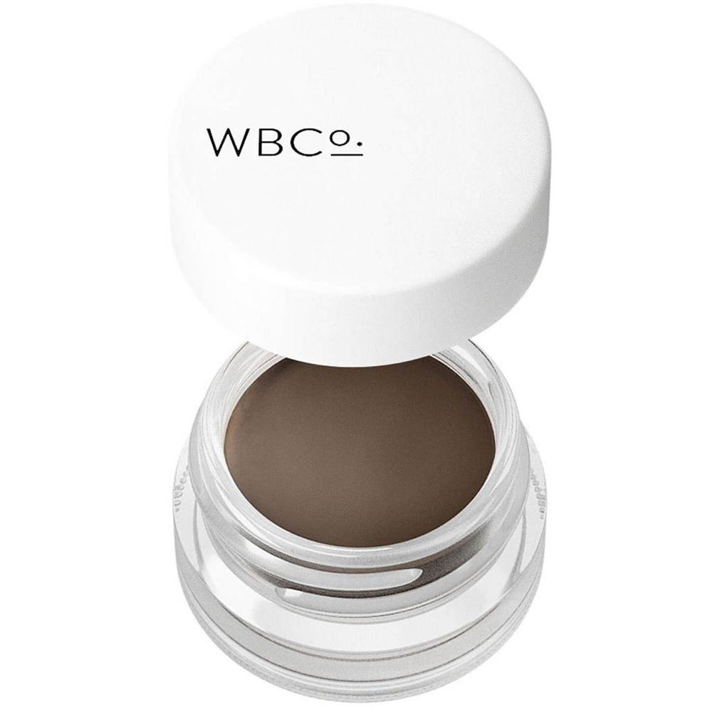 Glas mit Augenbrauen-Pomade. Deckel mit WBCo.-Logo. Cremige, braune Textur sichtbar.