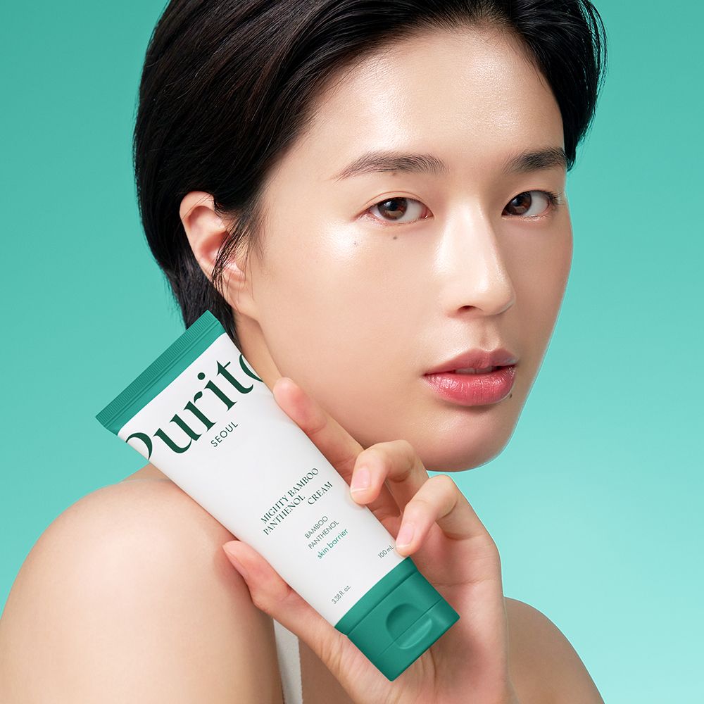 Frau hält eine Tube Purito Mighty Bamboo Panthenol Cream.