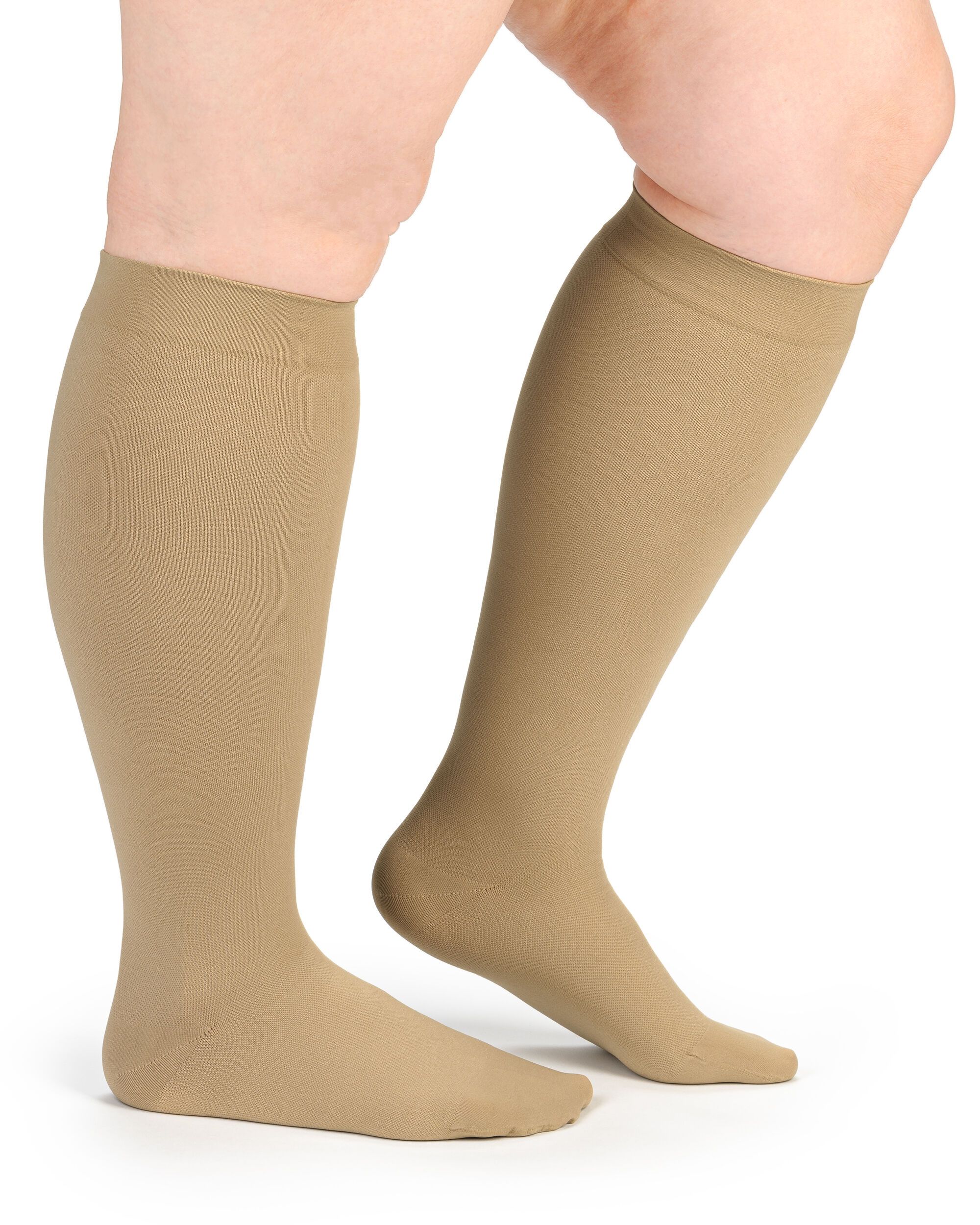 Beige Kompressionsstrümpfe am Bein einer Person. Kniestrümpfe aus Stoff. Blick von der Seite.