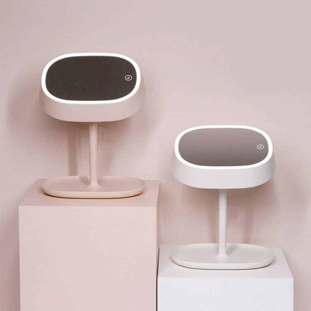 Zwei Lampen mit LED-Spiegel. Eine rosa, eine weiße. Ovaler Spiegel mit Beleuchtung, auf Podesten.