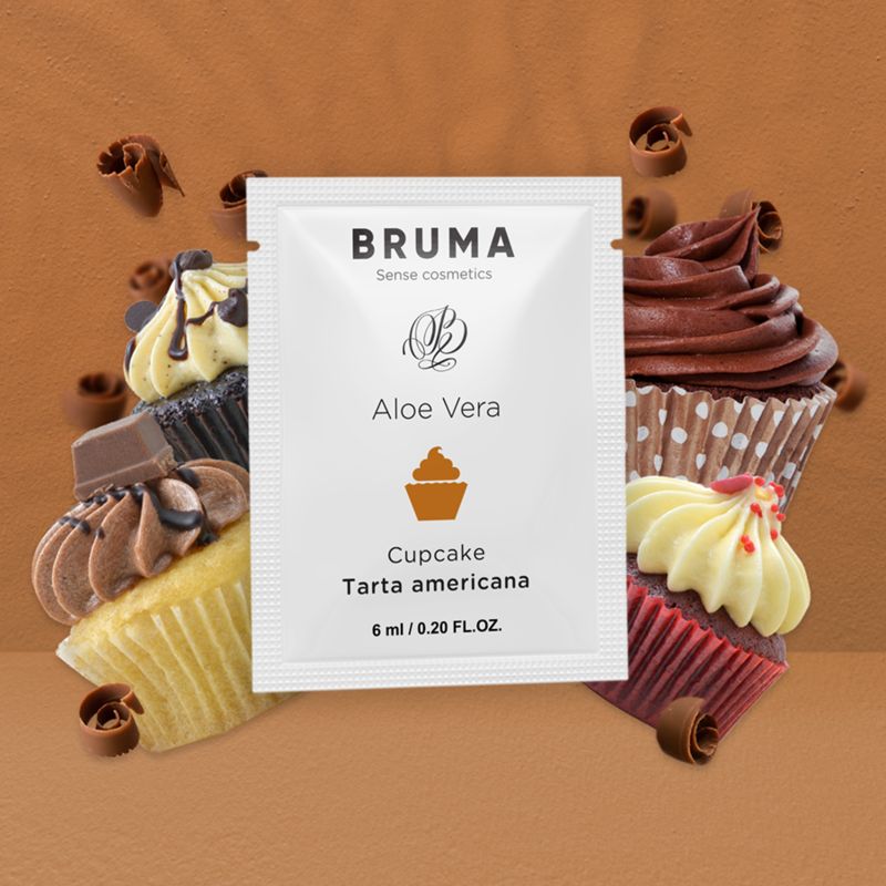 Weißer Beutel mit Produktinformationen, umgeben von Cupcakes und Schokoladenlocken. Aufdruck: BRUMA, Aloe Vera, Cupcake, Tarta americana, 6 ml / 0.20 FL.OZ.