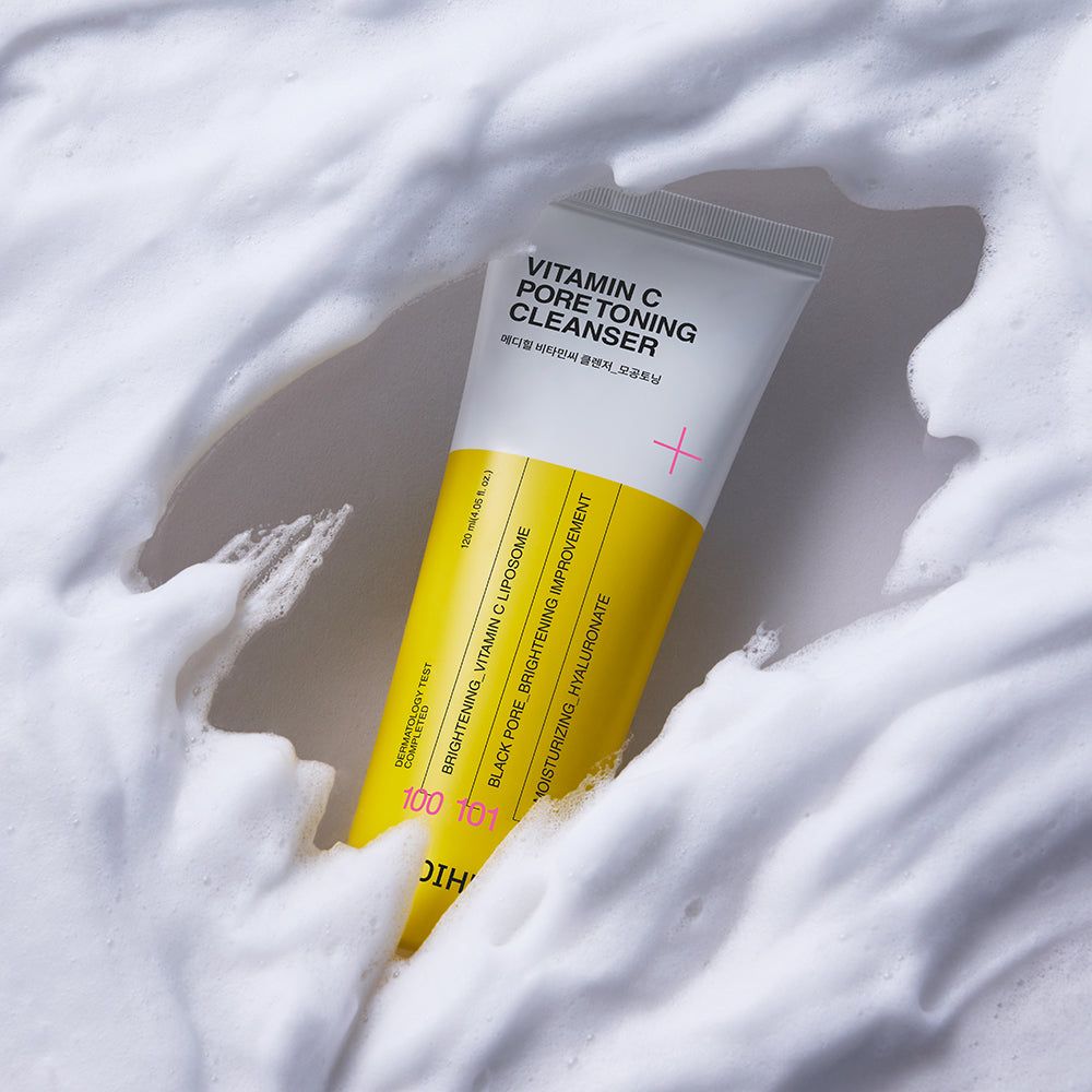 Gelbe Tube mit weißem Schaum. Aufschrift: Vitamin C Pore Toning Cleanser. Rosa Plus-Zeichen. Gelber Streifen mit Text.