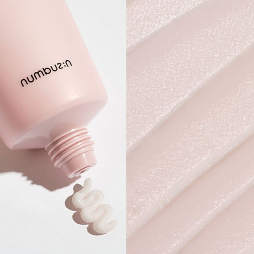 Creme-Tube mit rosa Design. Creme wird herausgedrückt. Marke: numbuz:n. Creme-Textur.