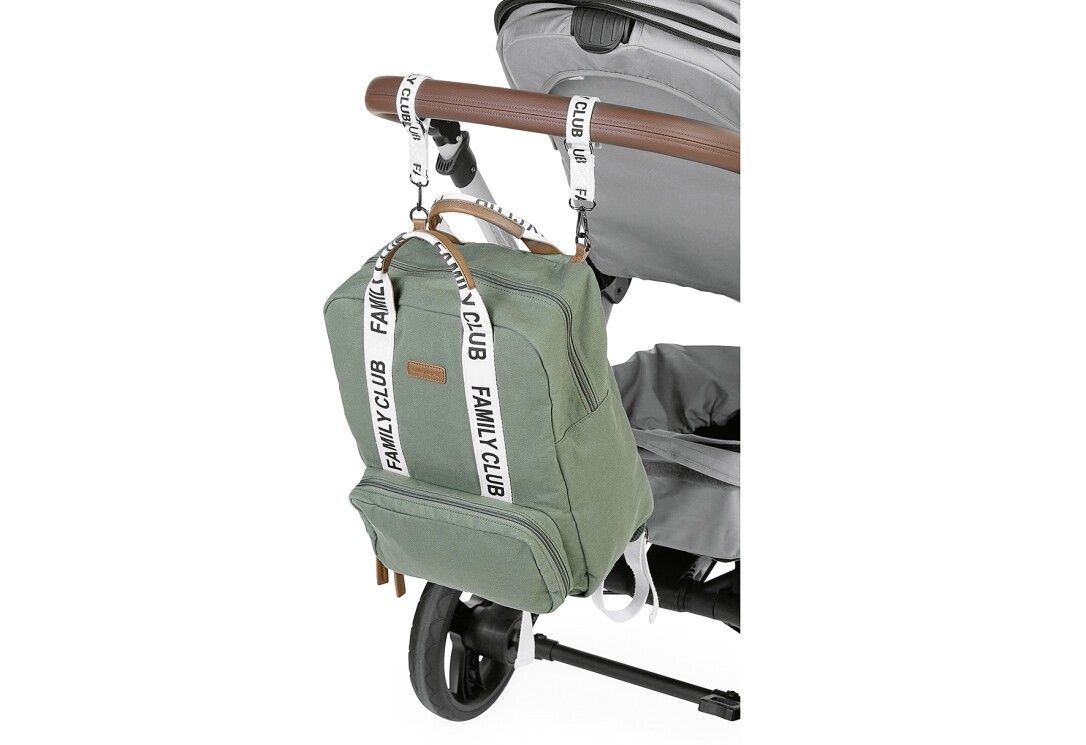 Grüner Wickelrucksack an einem Kinderwagen befestigt. Weiße Träger mit FAMILY CLUB-Schriftzug. Braune Griffe.