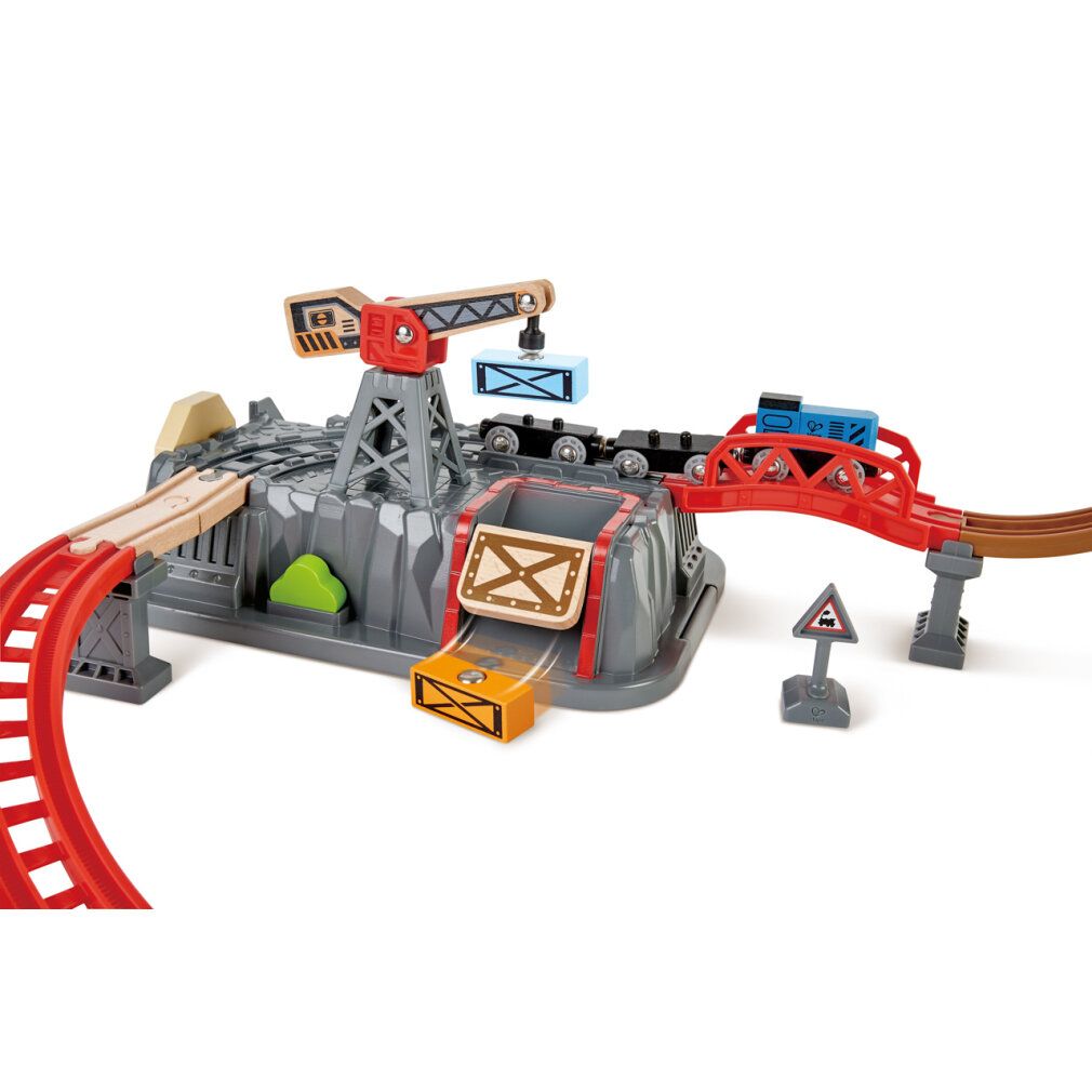 Nahaufnahme des Eisenbahn-Baukasten-Sets. Enthält eine graue Felsenbasis, eine rote Brücke und einen Kran. Züge und Container sind sichtbar.