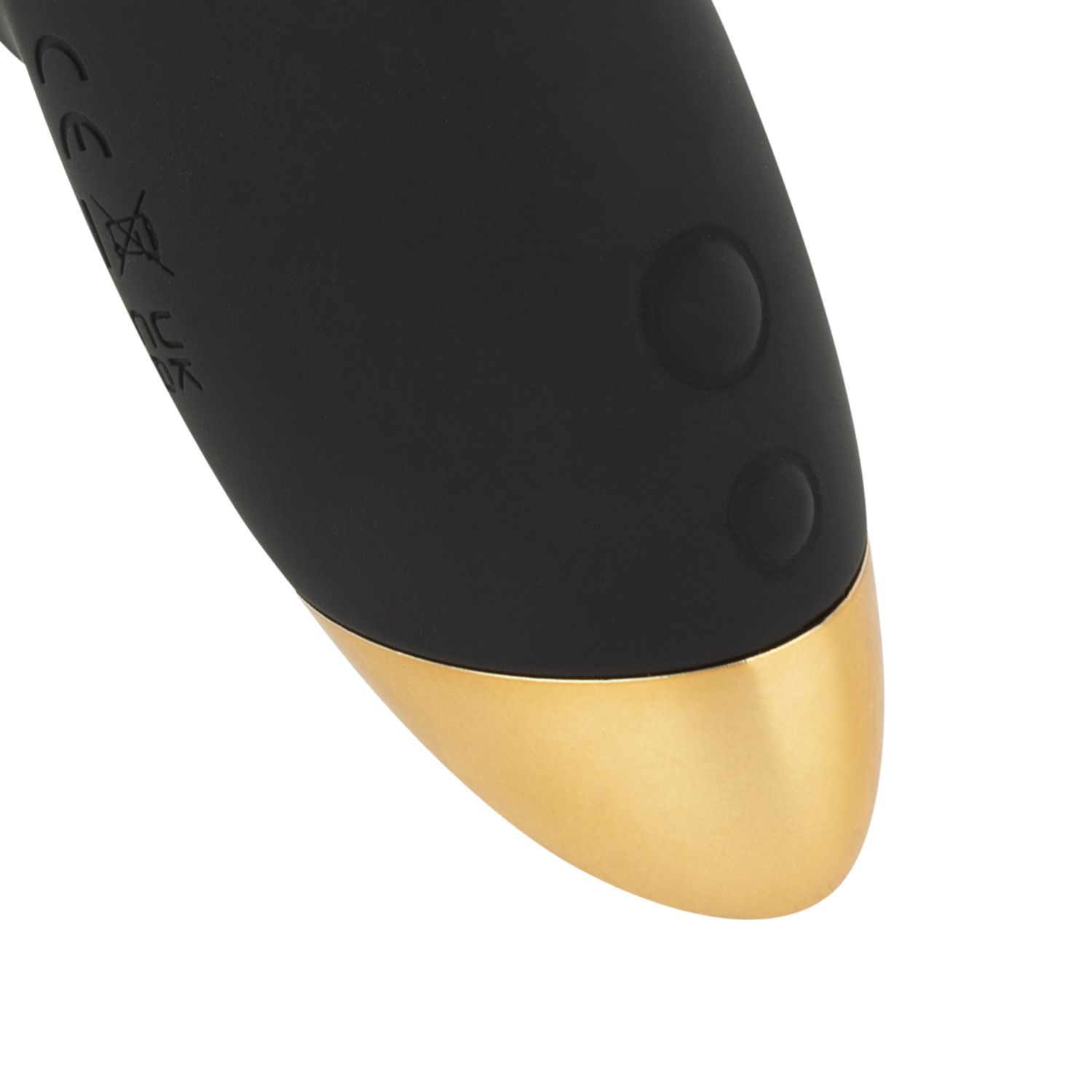 Nahaufnahme des Vibrator-Endes. Schwarzes Gehäuse mit zwei Knöpfen und goldfarbenem Ende. Auf weißem Hintergrund.