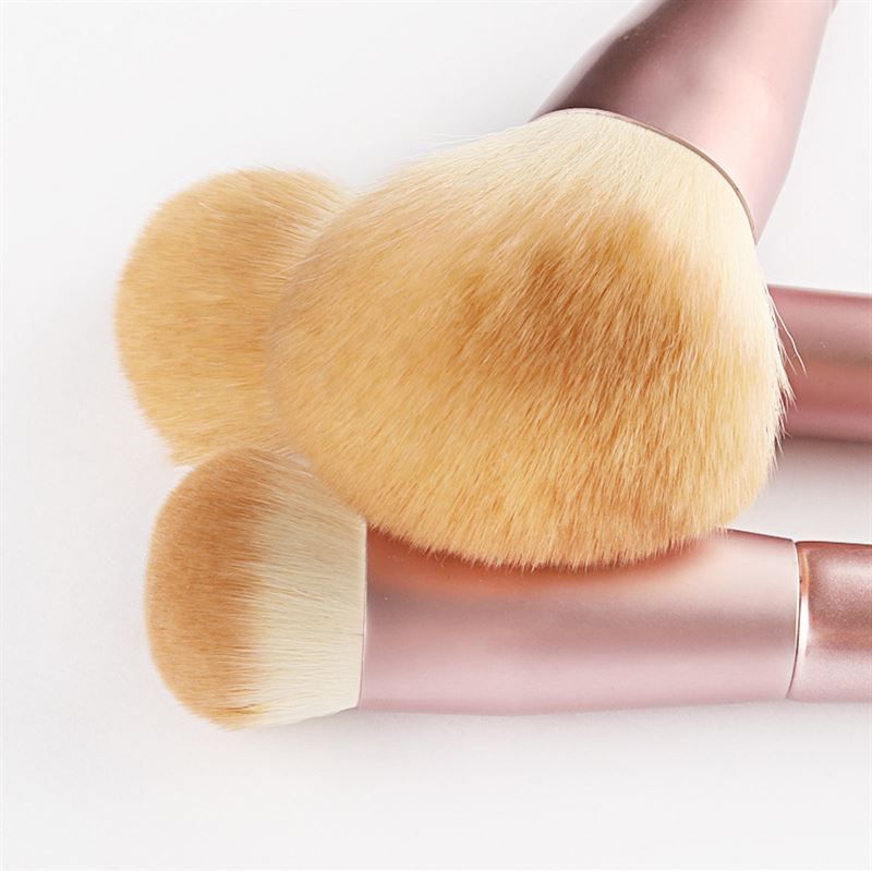 Nahaufnahme von drei Make-up-Pinseln. Rosa Griffe, helle Borsten. Verschiedene Formen. Auf weißem Hintergrund.