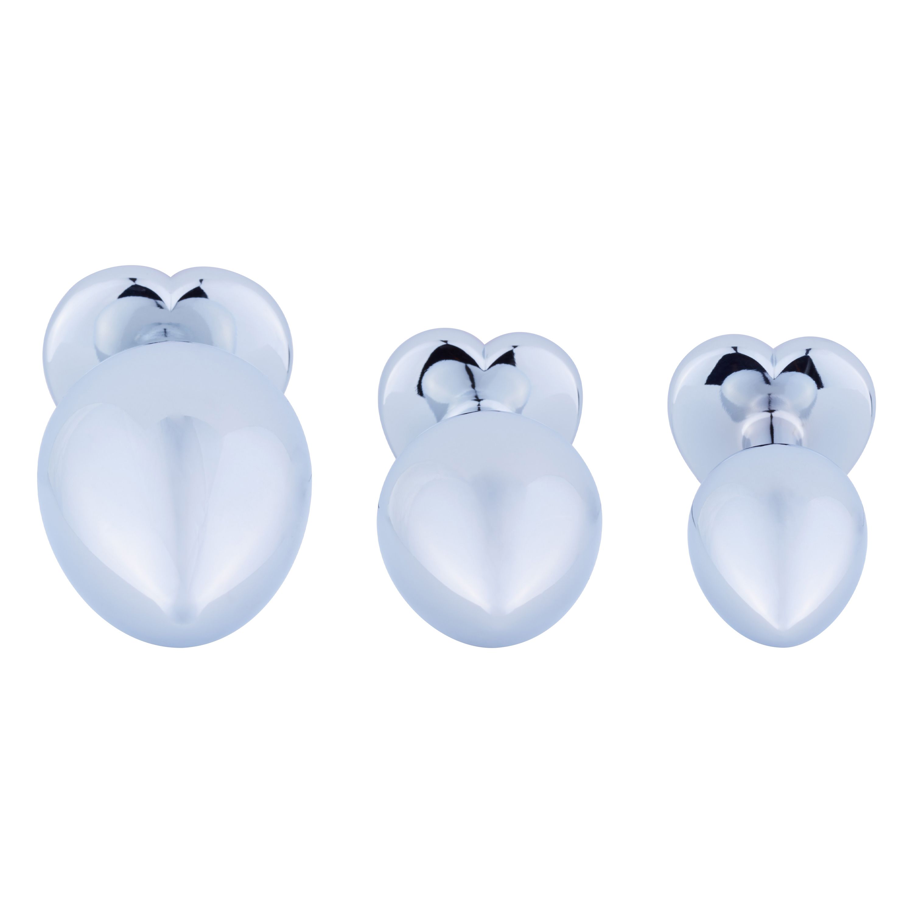 Drei metallische Anal-Plugs in Herzform. Unterschiedliche Größen, glänzende Oberfläche.