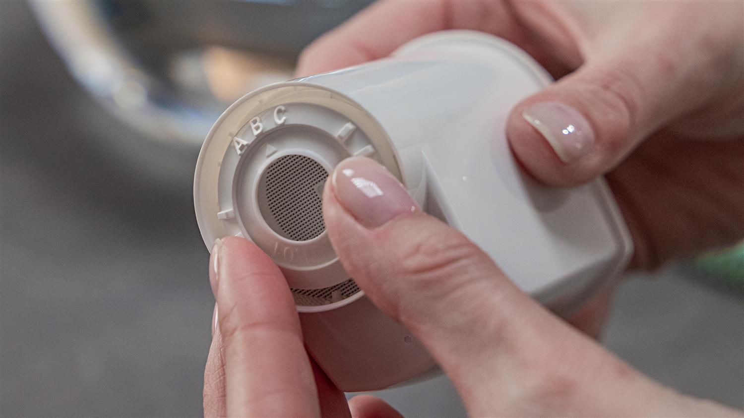 Nahaufnahme eines Wasserfilters. Filter mit Buchstaben A, B, C. Hände halten den Filter.