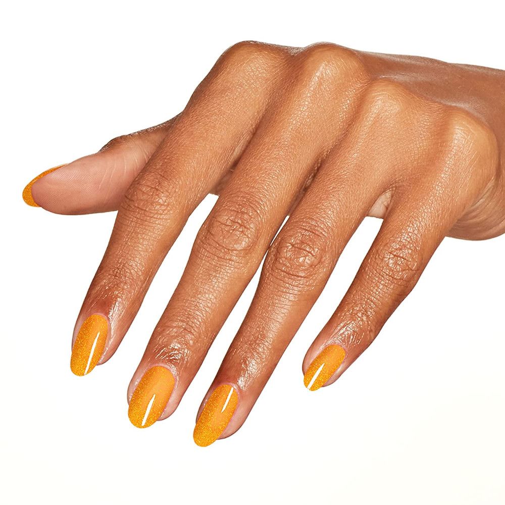 Hand mit lackierten Fingernägeln in Orange. Glitzerpartikel sichtbar.