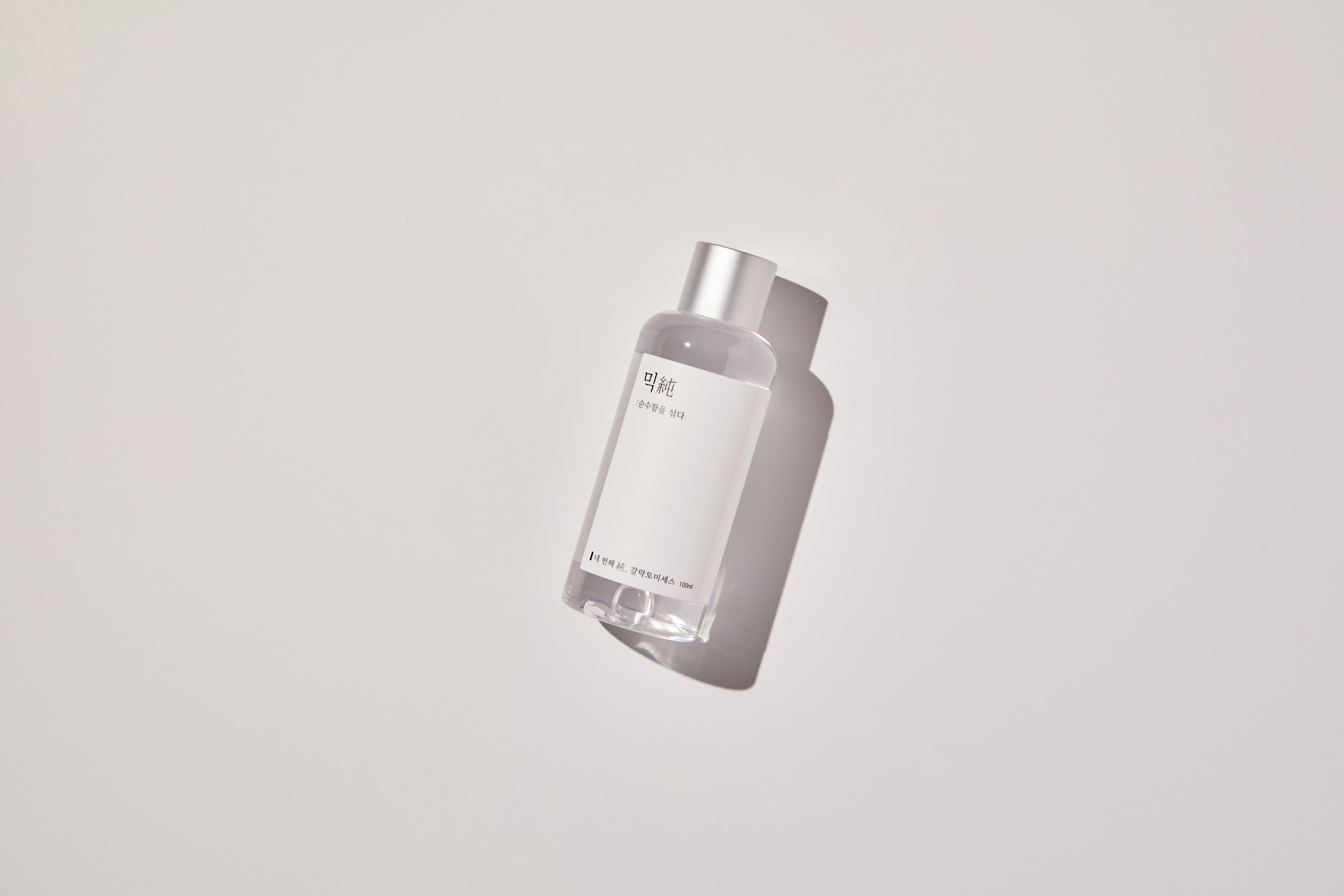 Flasche Mixsoon Galactomyces Ferment Essence liegt auf heller Oberfläche mit Schatten.
