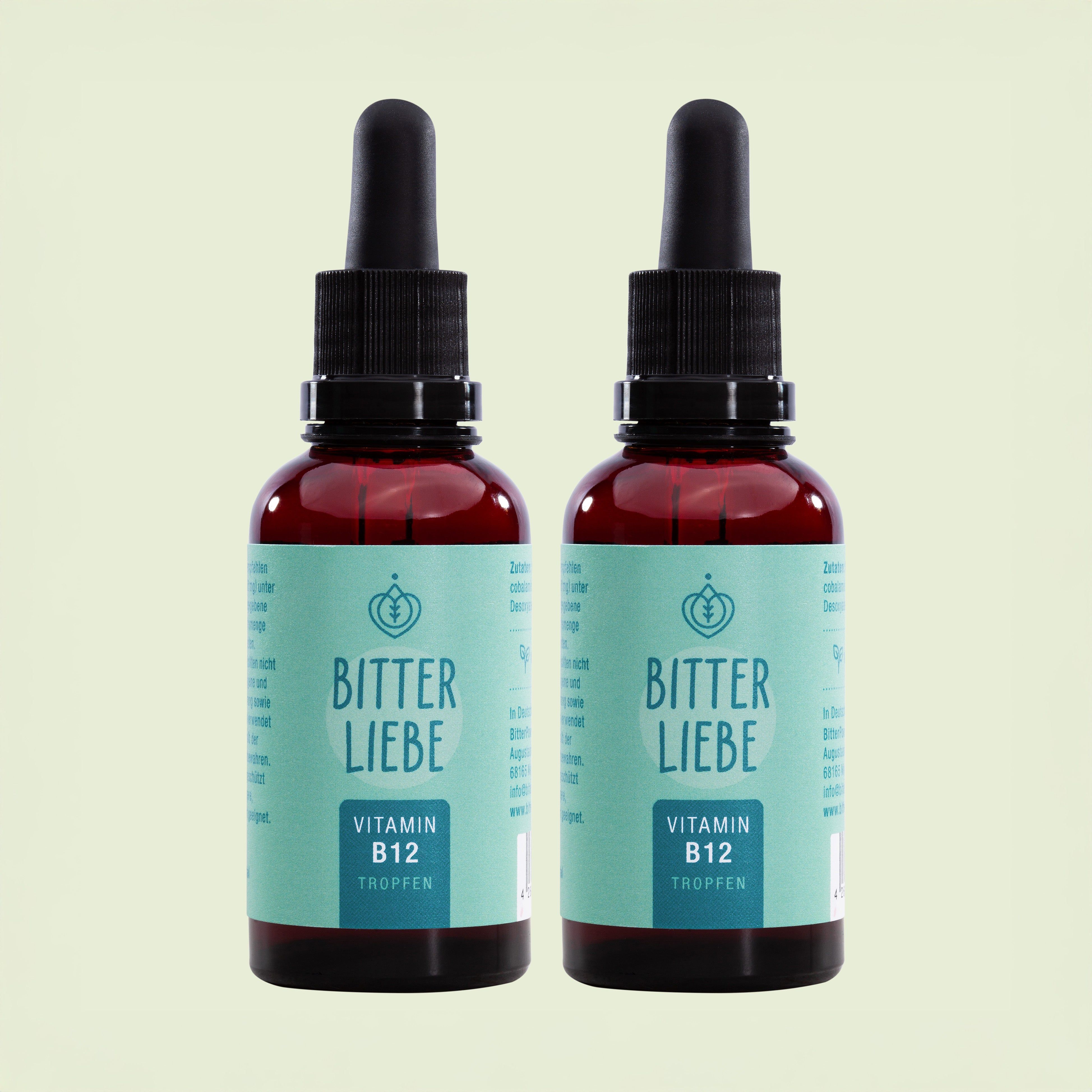 Zwei Flaschen BitterLiebe Vitamin B12 Tropfen. Braune Glasflaschen mit schwarzer Pipette und hellgrünem Etikett.