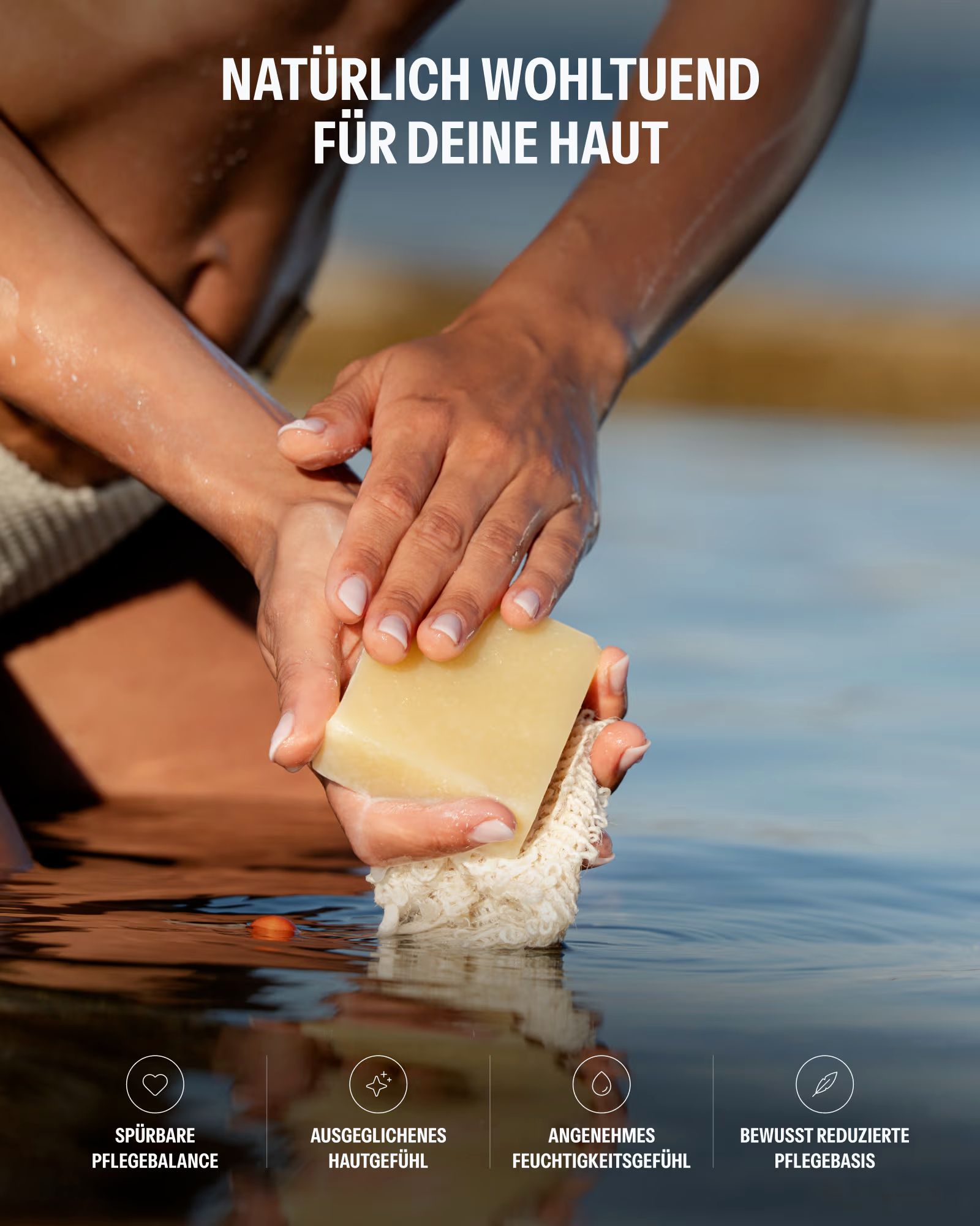 Hände halten ein Stück Seife in Wasser, mit Schaum und einem Netz.