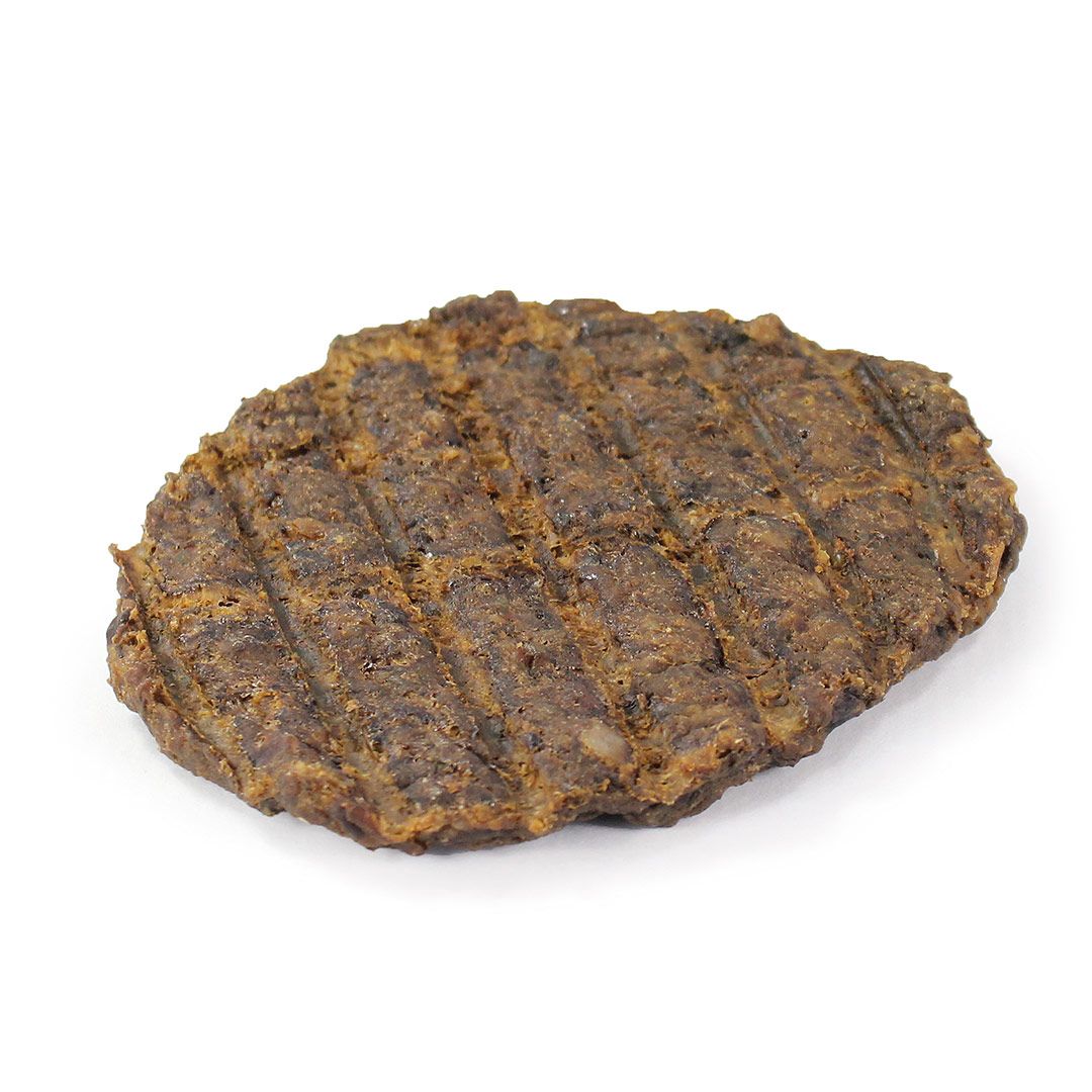 Fleischiger Kausnack für Hunde. Ovale Form, braune Farbe, mit Grillmuster. Auf weißem Hintergrund.