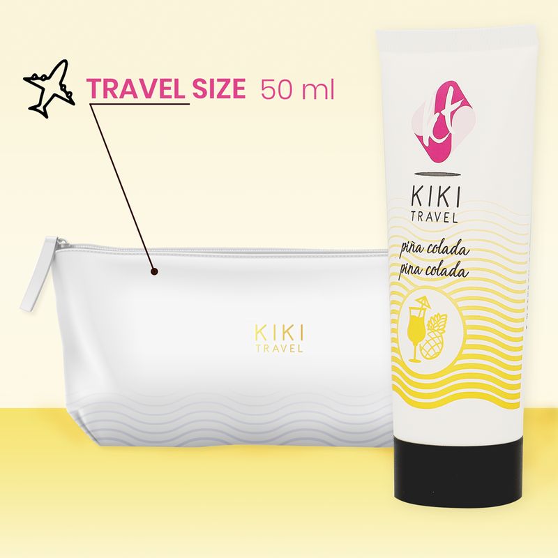 Weiße Tube mit schwarzem Deckel und Aufschrift: KIKI TRAVEL, pina colada. Daneben eine transparente Kosmetiktasche.