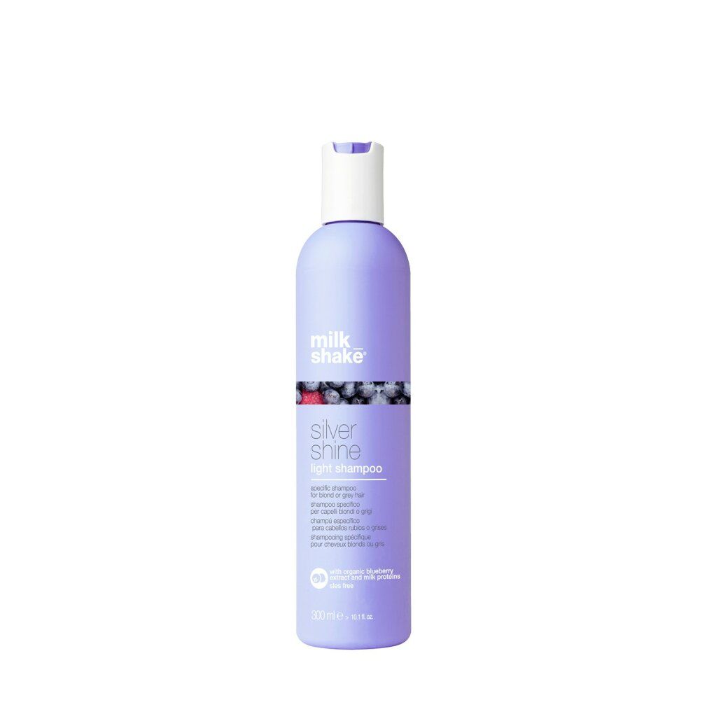 Shampoo-Flasche. Lila Flasche mit weißem Deckel. Aufschrift: Milk Shake, Silver Shine Light Shampoo. Mit Blaubeere.