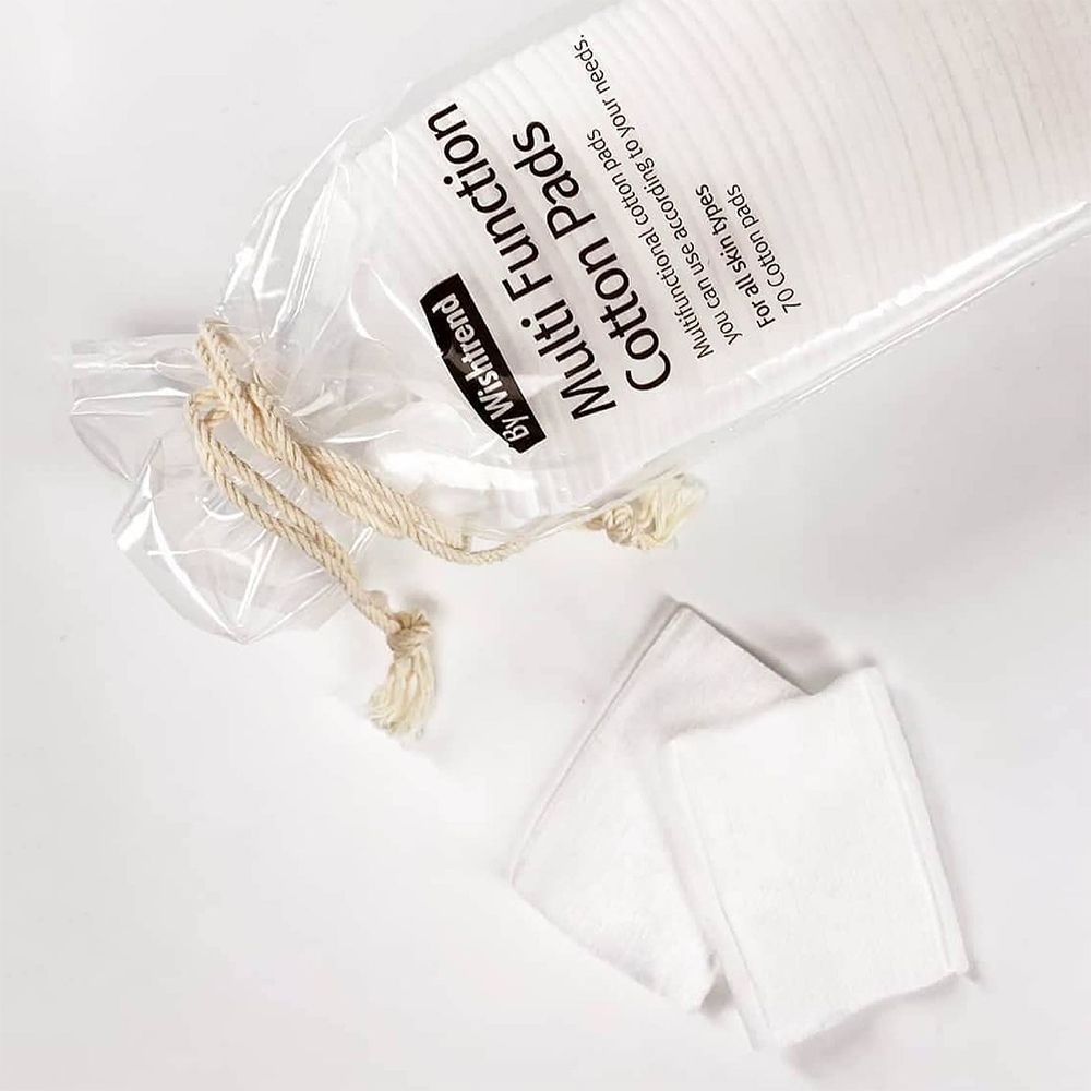 Geöffnete Verpackung mit Wattepads. Zwei Pads liegen daneben. Aufschrift: By Wishtrend Multi Function Cotton Pads. Transparente Verpackung.