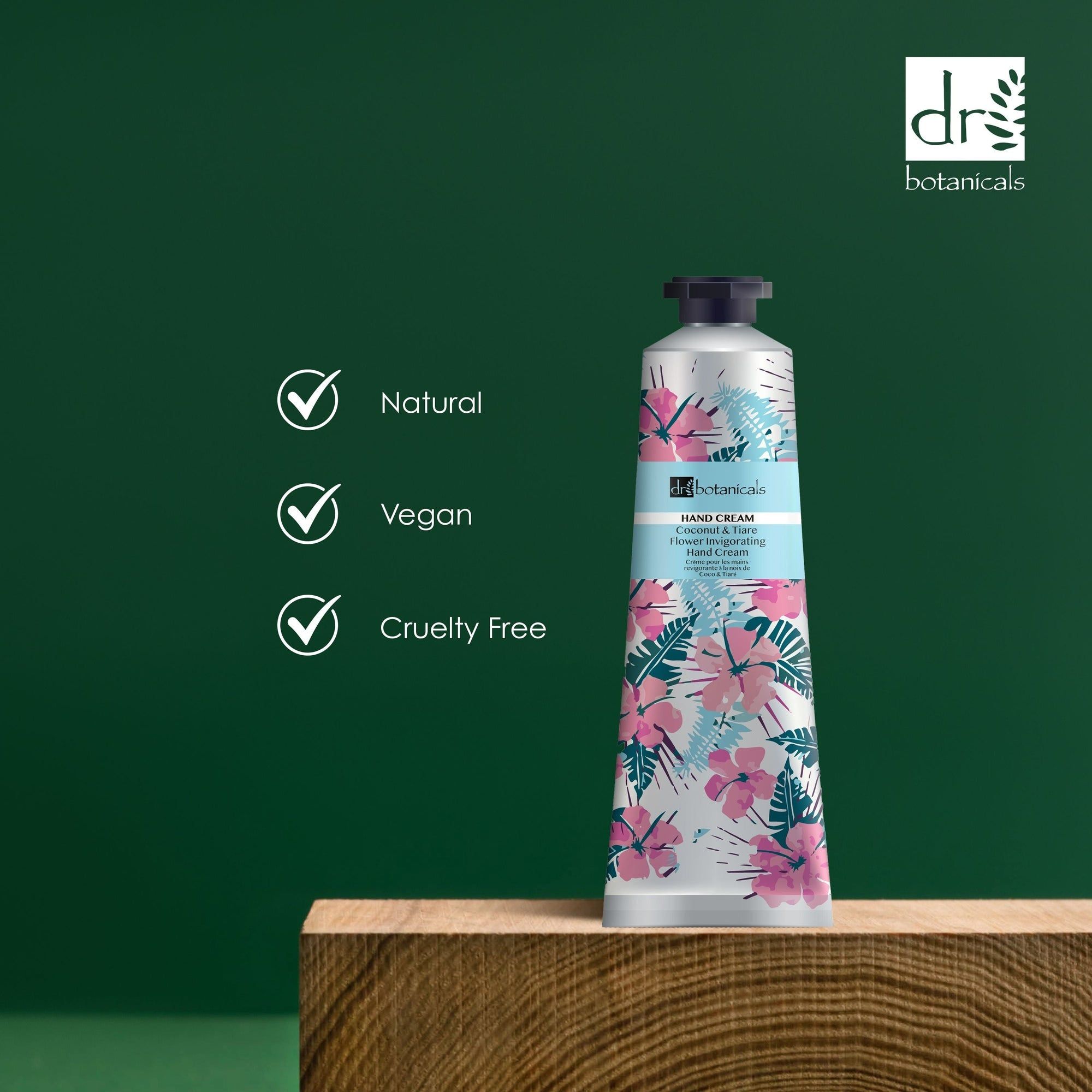Tube auf Holzblock. Aufschrift: Hand Cream, Coconut & Tiare Flower Invigorating Hand Cream. Logos: Natural, Vegan, Cruelty Free.