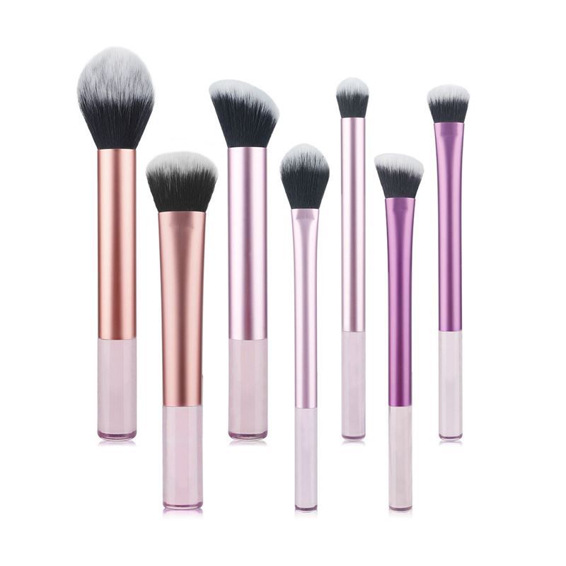 Sieben Make-up Pinsel mit schwarzen Borsten und rosa, lila und silberfarbenen Griffen. Unterschiedliche Formen und Größen.