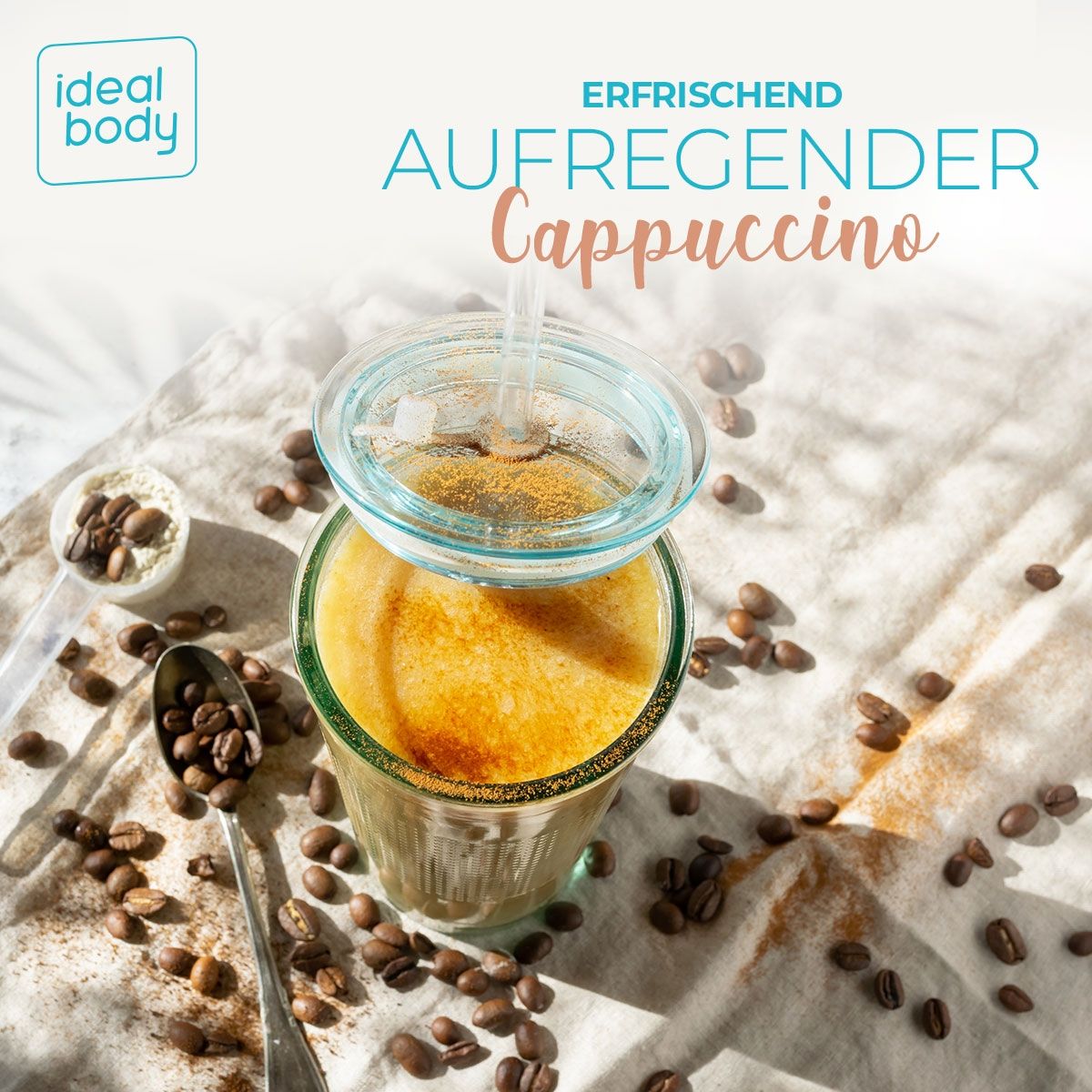 Glas Cappuccino mit Deckel und Strohhalm. Löffel und Kaffeebohnen. Text: 'ERFRISCHEND AUFREGENDER Cappuccino'.