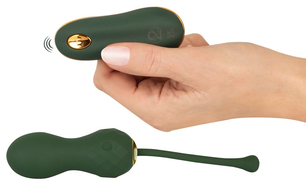 Grüne RC Love Balls und Fernbedienung. Die Fernbedienung wird in einer Hand gehalten. Die Kugeln haben eine facettierte Oberfläche.