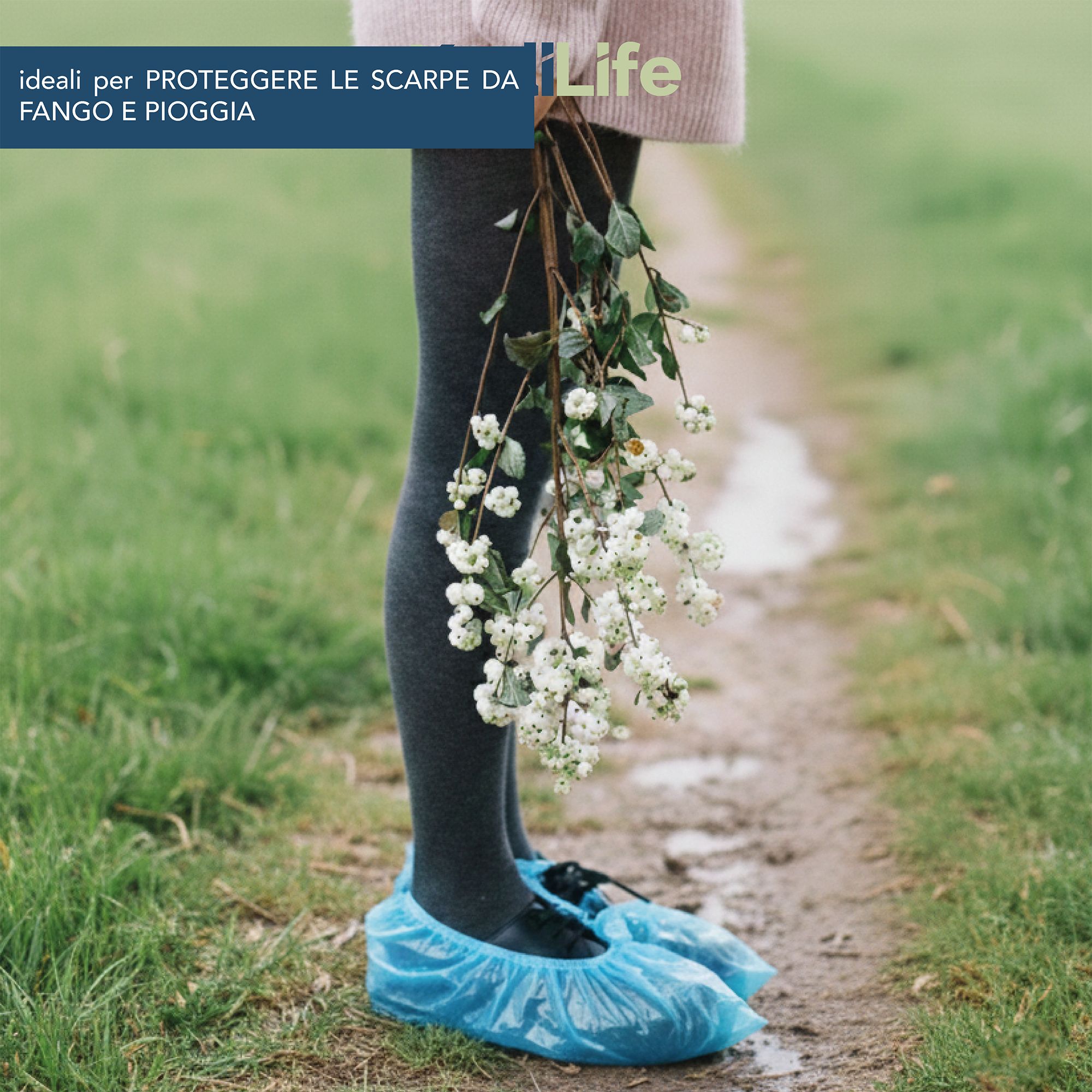 Person mit blauen Überschuhen und Blumenstrauß auf einem Feldweg.