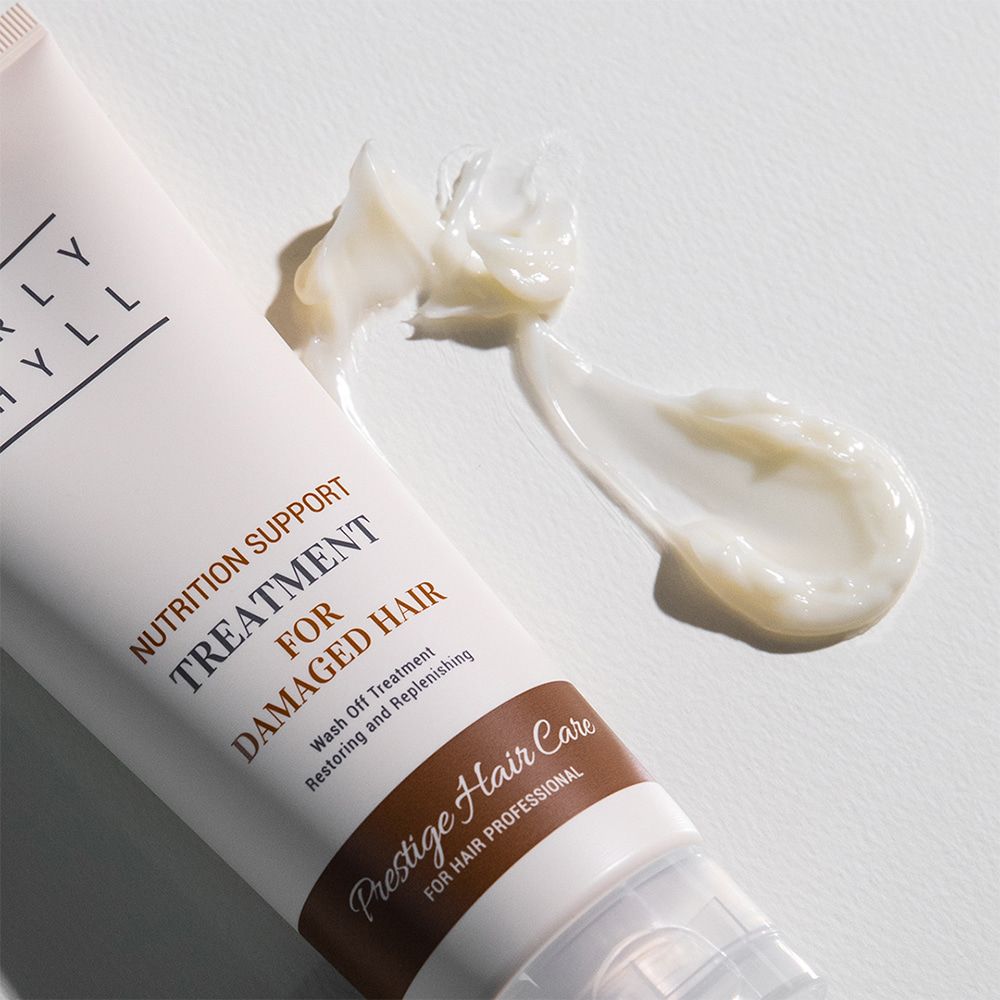 Tube und Produktprobe. Aufschrift: CURLY SHYLL, Nutrition Support Treatment for Damaged Hair, Prestige Hair Care.
