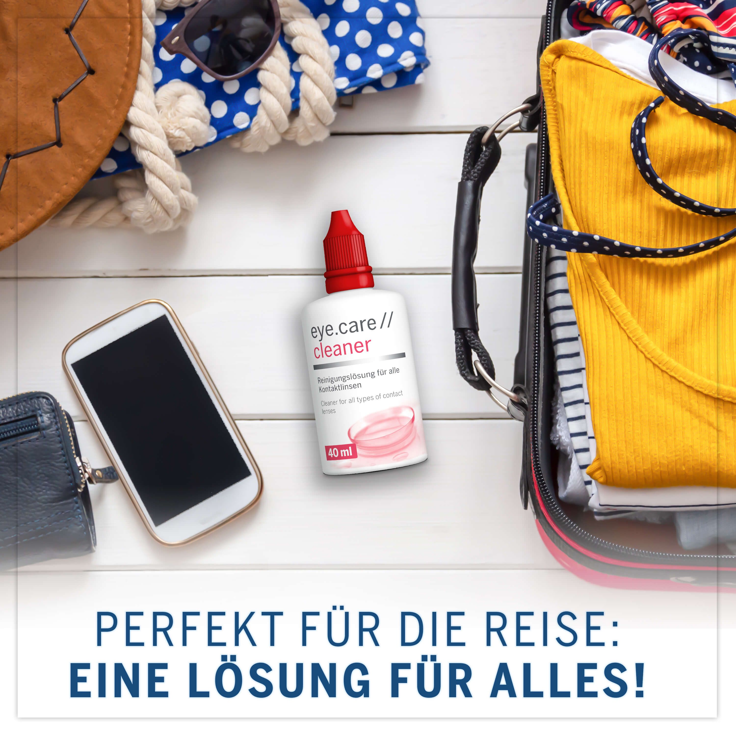 Weiße Flasche mit rotem Verschluss neben Gepäck, Handy und Accessoires. Text: eye.care // cleaner, 40 ml.