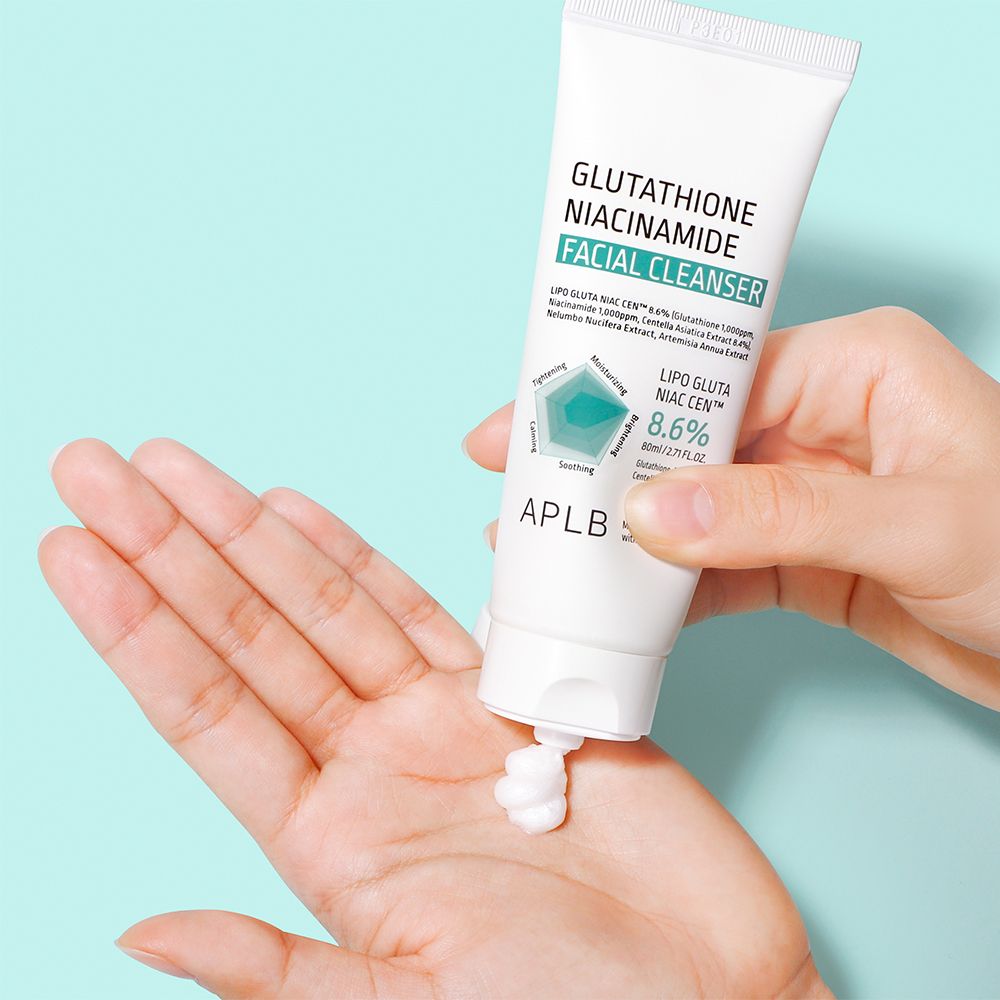 Hand drückt weiße Tube, Gesichtsreiniger wird auf Handfläche gegeben. Enthält 8,6% Lipo Gluta Niac Cen.